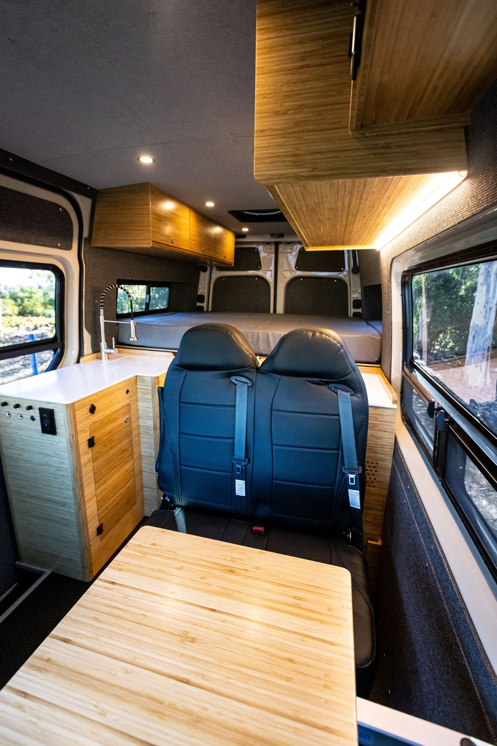 the inside of a van with a bed and a table .
