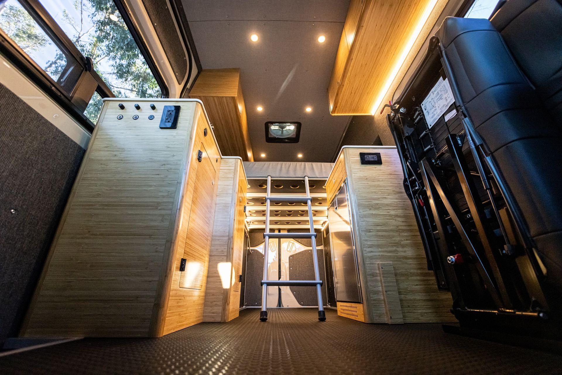 the inside of a van with a ladder and a bunk bed .