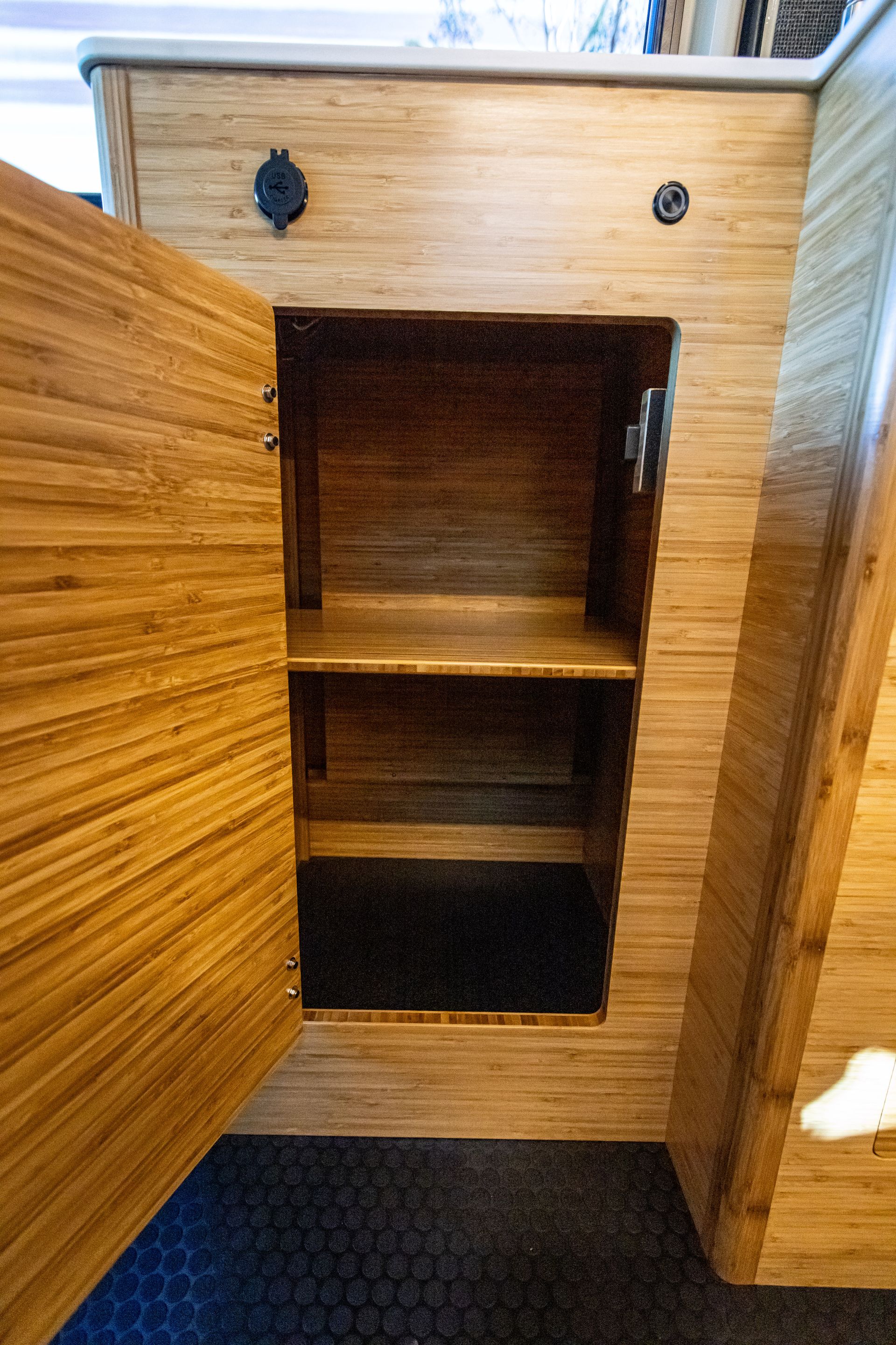 a wooden cabinet with the door open and two shelves .
