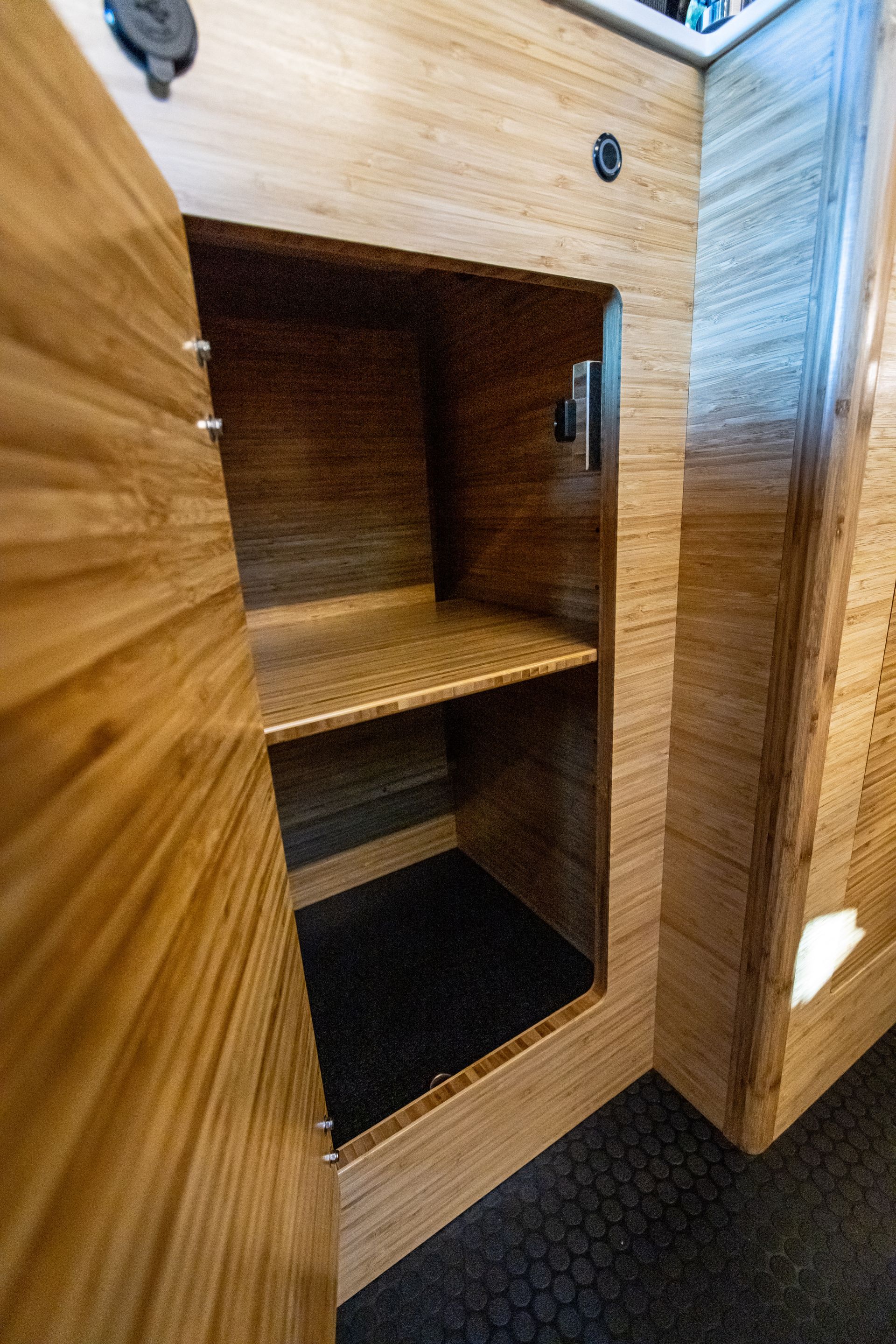 a wooden cabinet with the door open and a shelf inside of it .