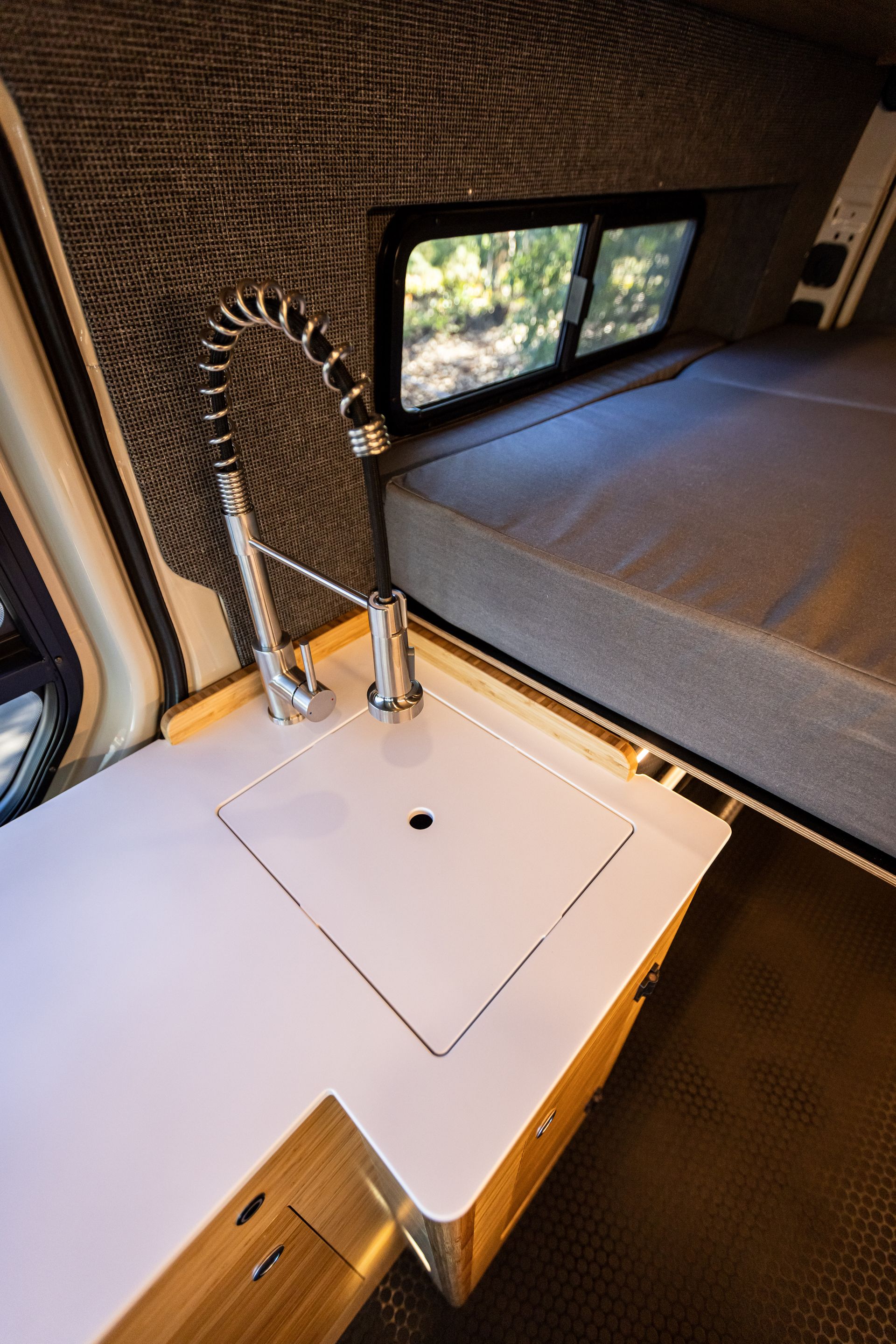 a camper van with a sink and a bed .