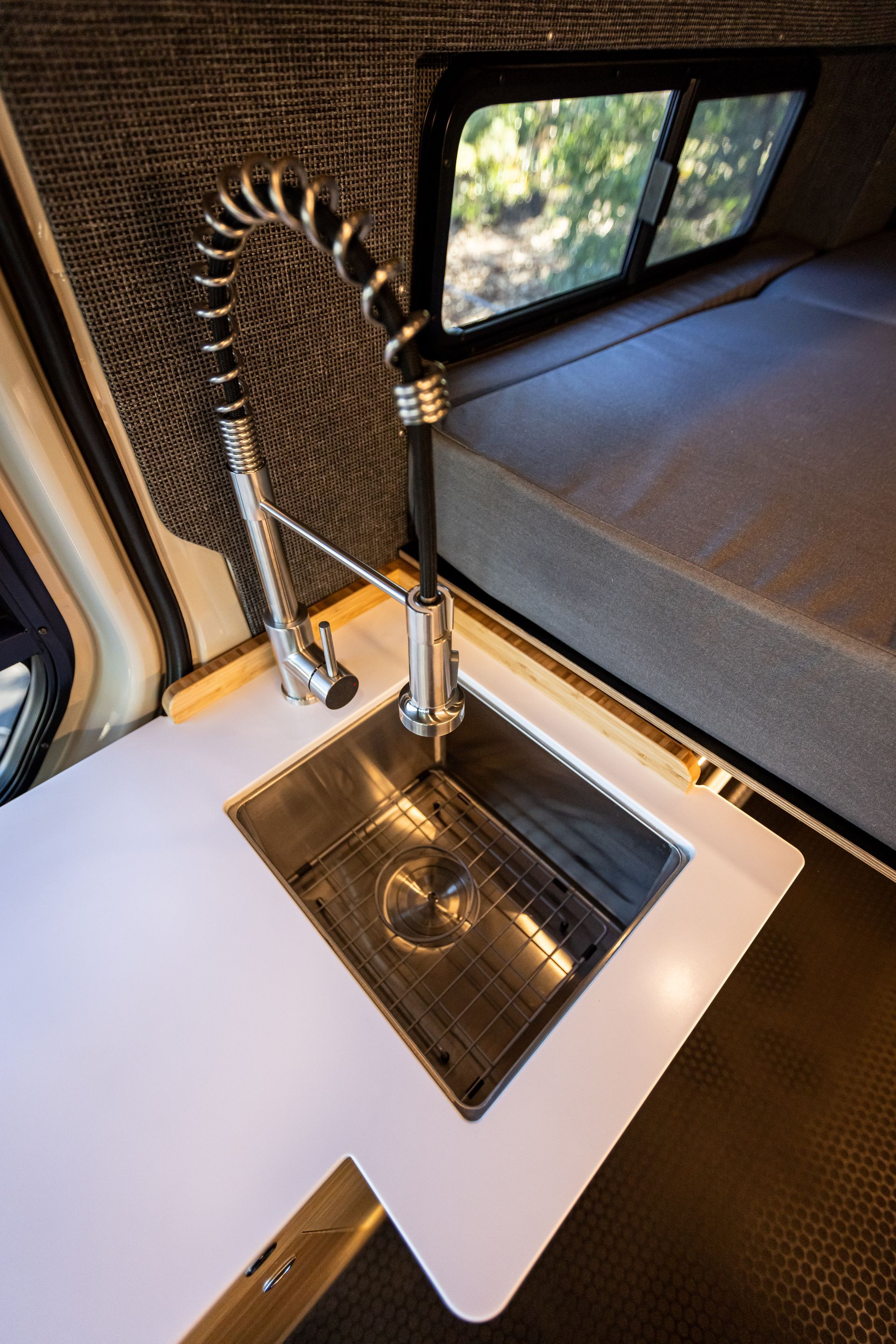 a stainless steel sink with a faucet in a van .