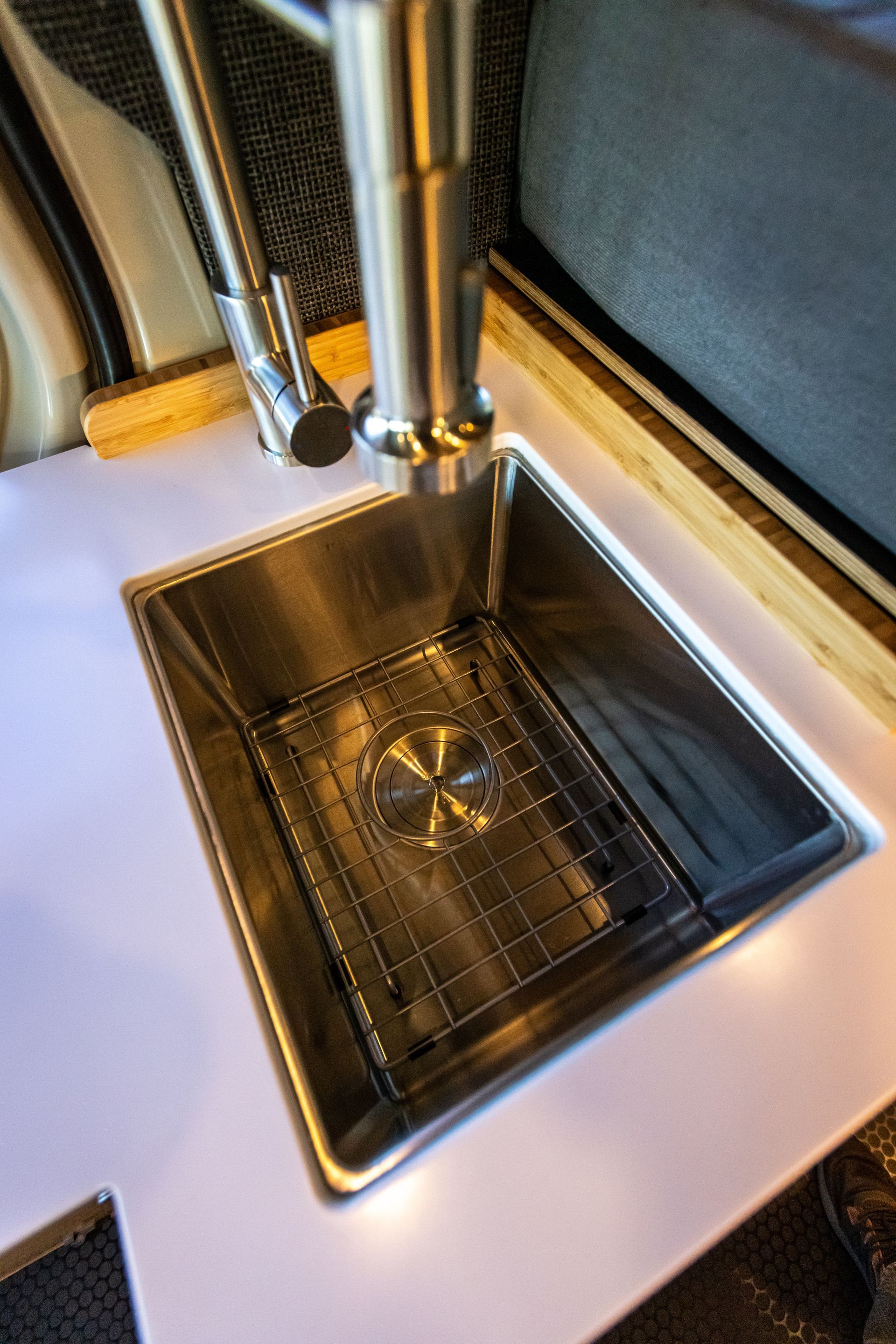 a stainless steel sink is sitting on top of a white counter .