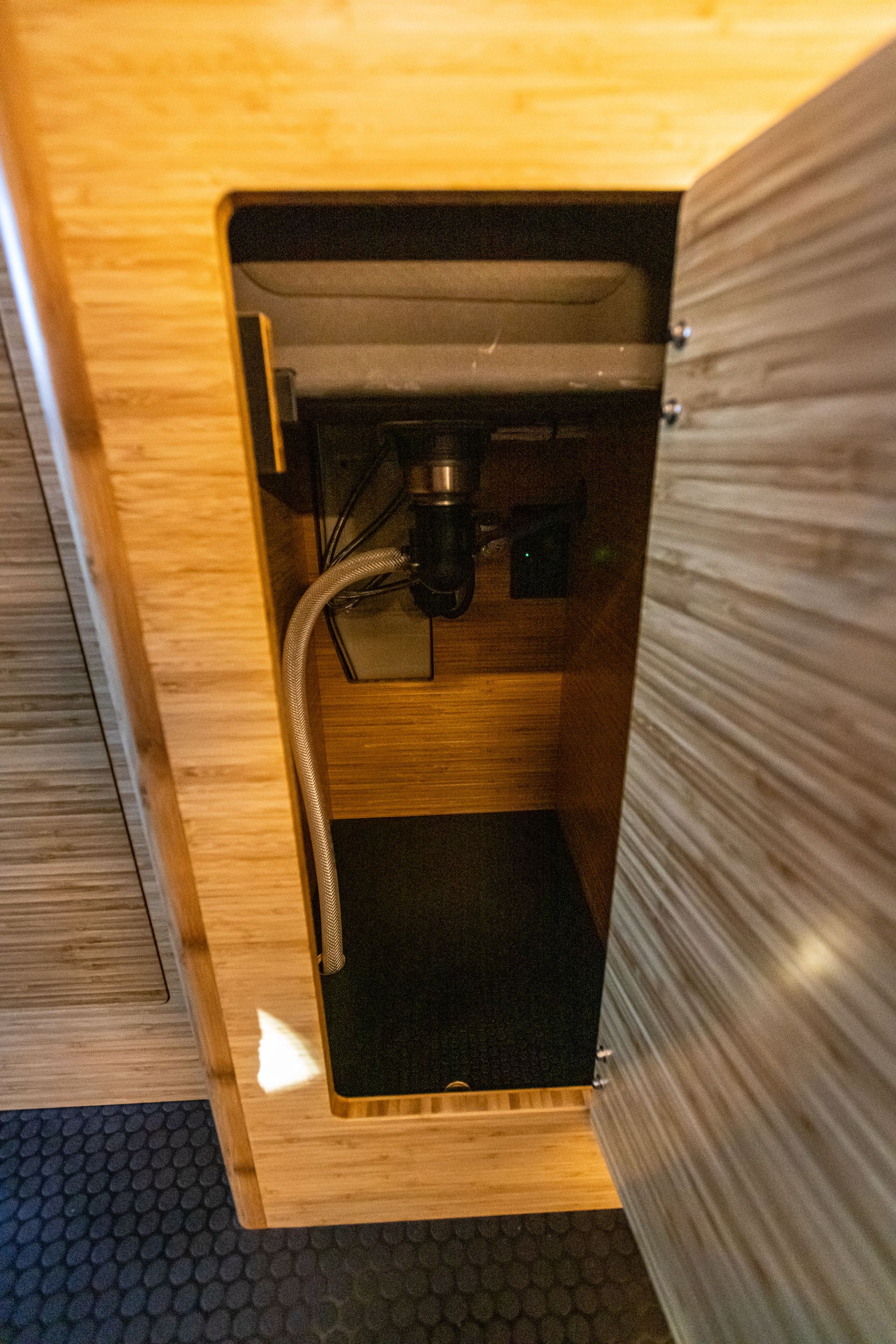 a sink is hidden under a wooden cabinet in a bathroom .
