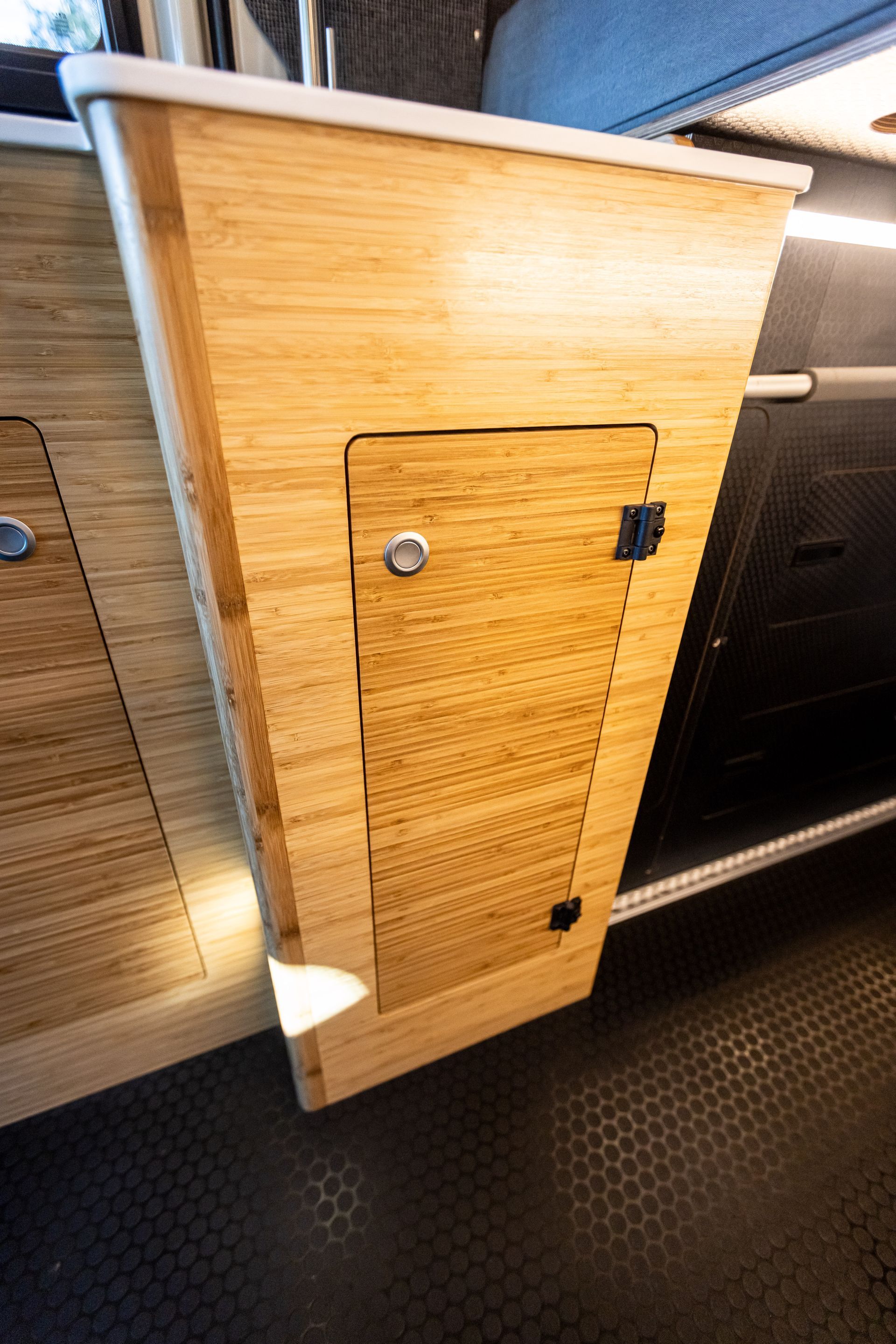a wooden cabinet with a door in a camper van .