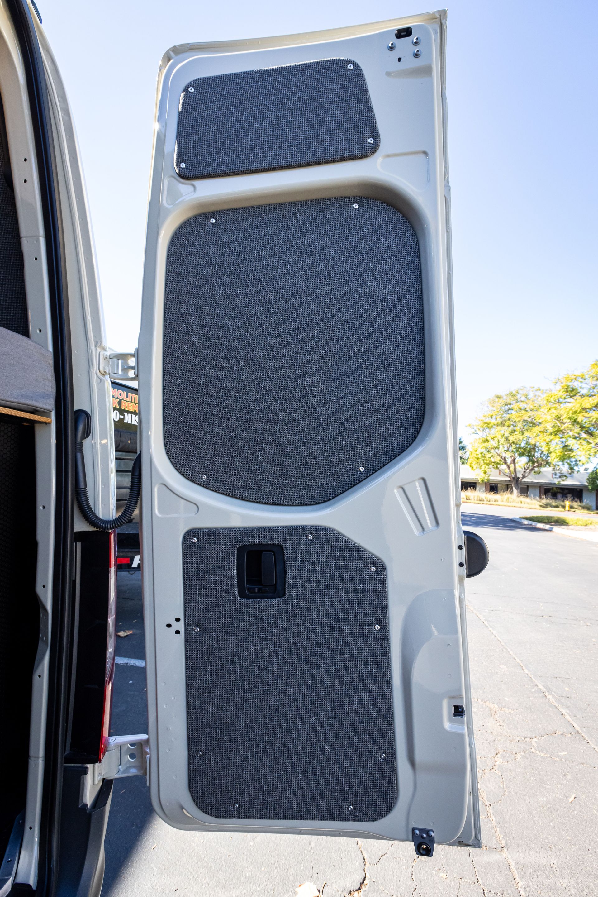 a white van with the door open is parked on the side of the road .
