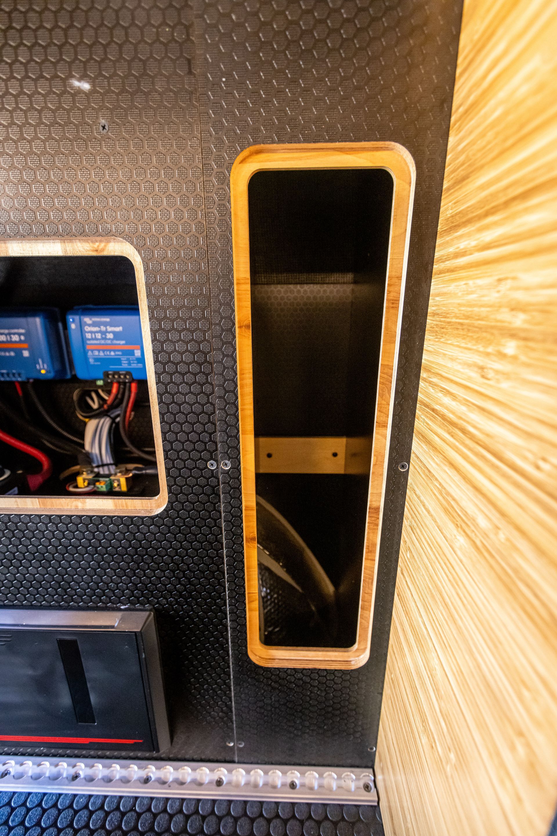 a black wall with a wooden frame and a shelf in it .