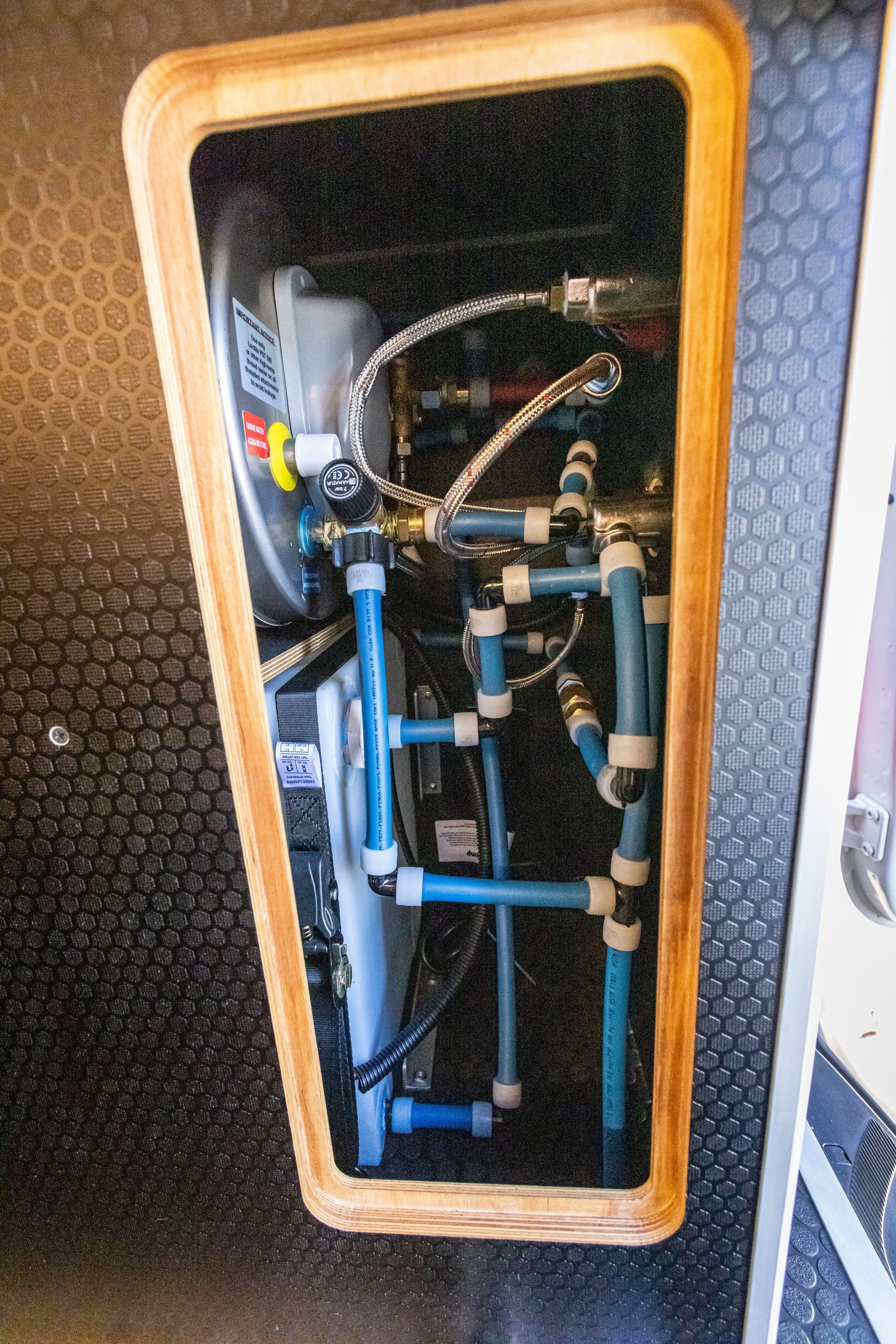 the inside of a boat with blue pipes and a wooden frame .
