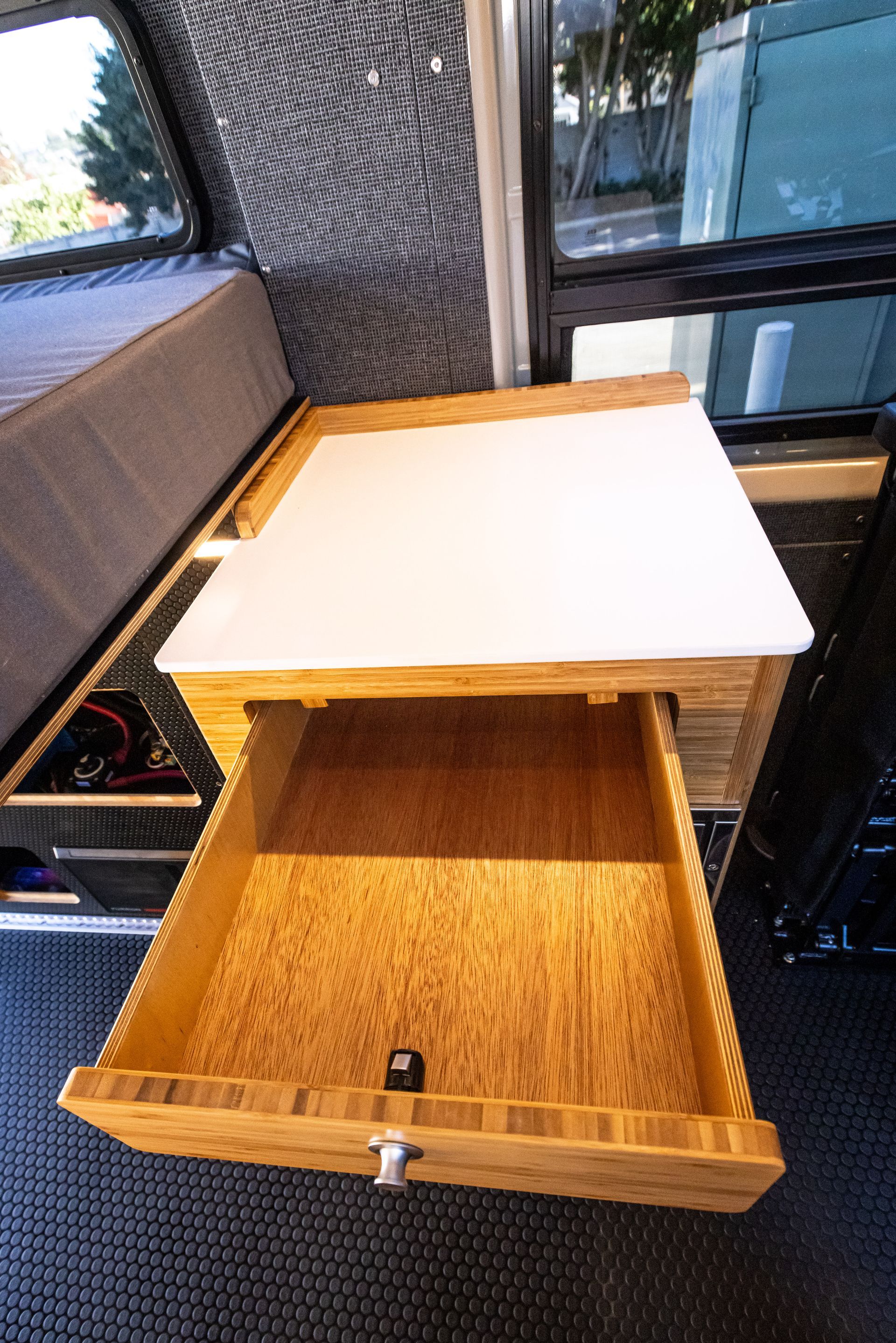 a wooden table with a drawer underneath it in a camper van .