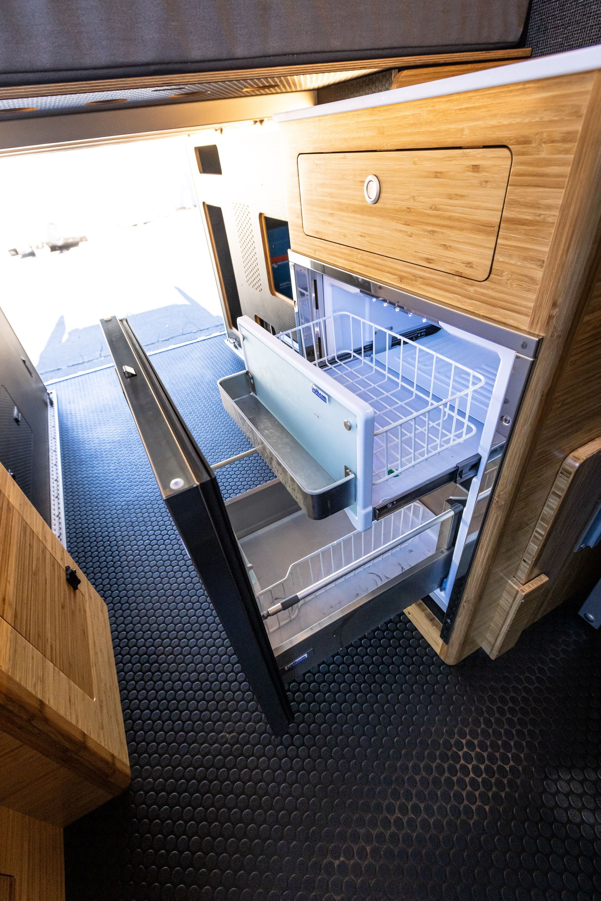 a refrigerator in a wooden cabinet with the door open .