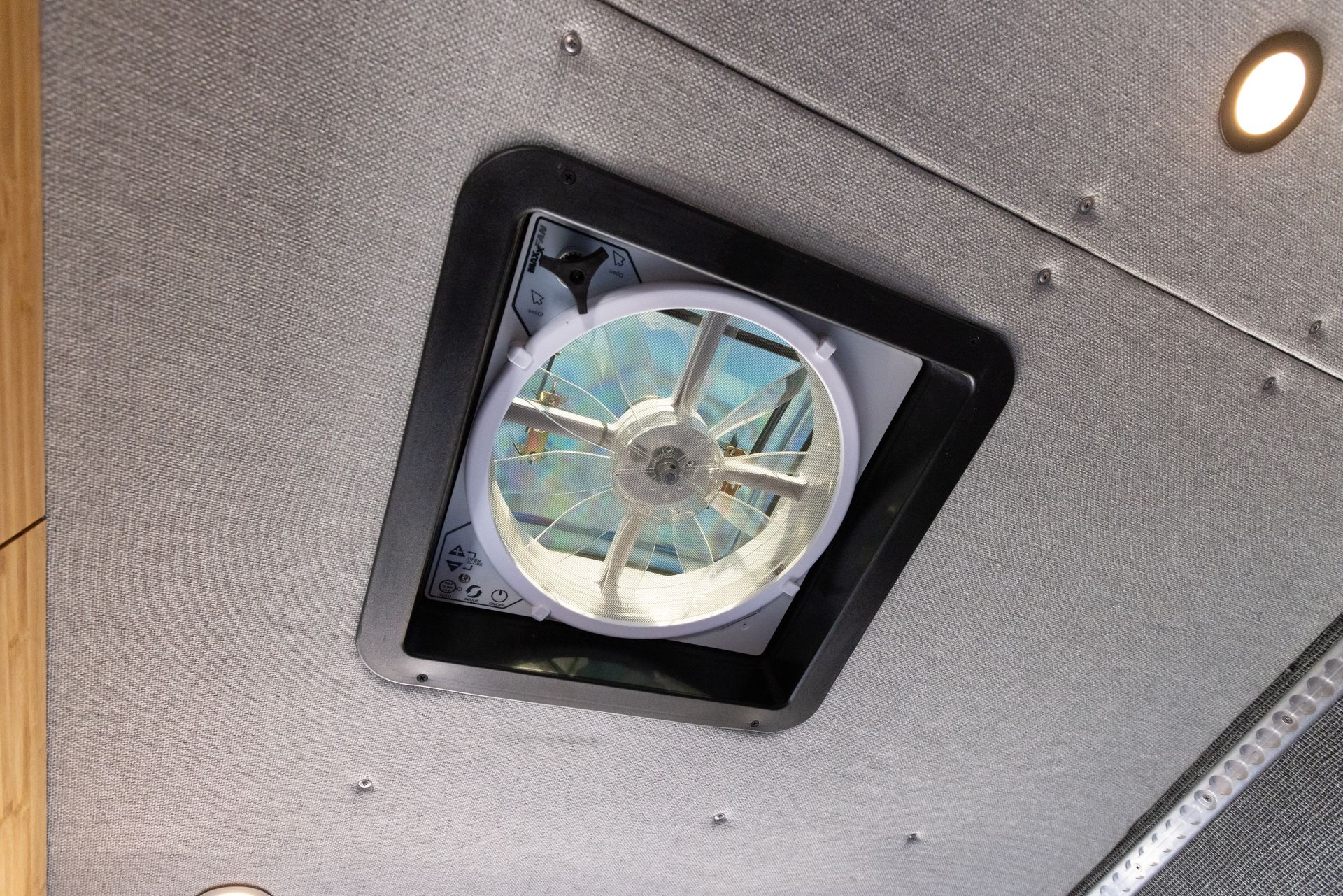 a fan is mounted to the ceiling of a vehicle .
