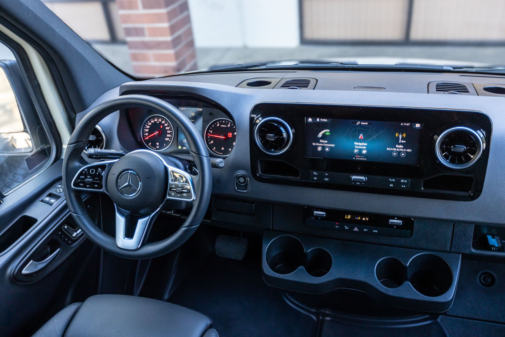 The interior of a mercedes benz sprinter van with a steering wheel and dashboard.