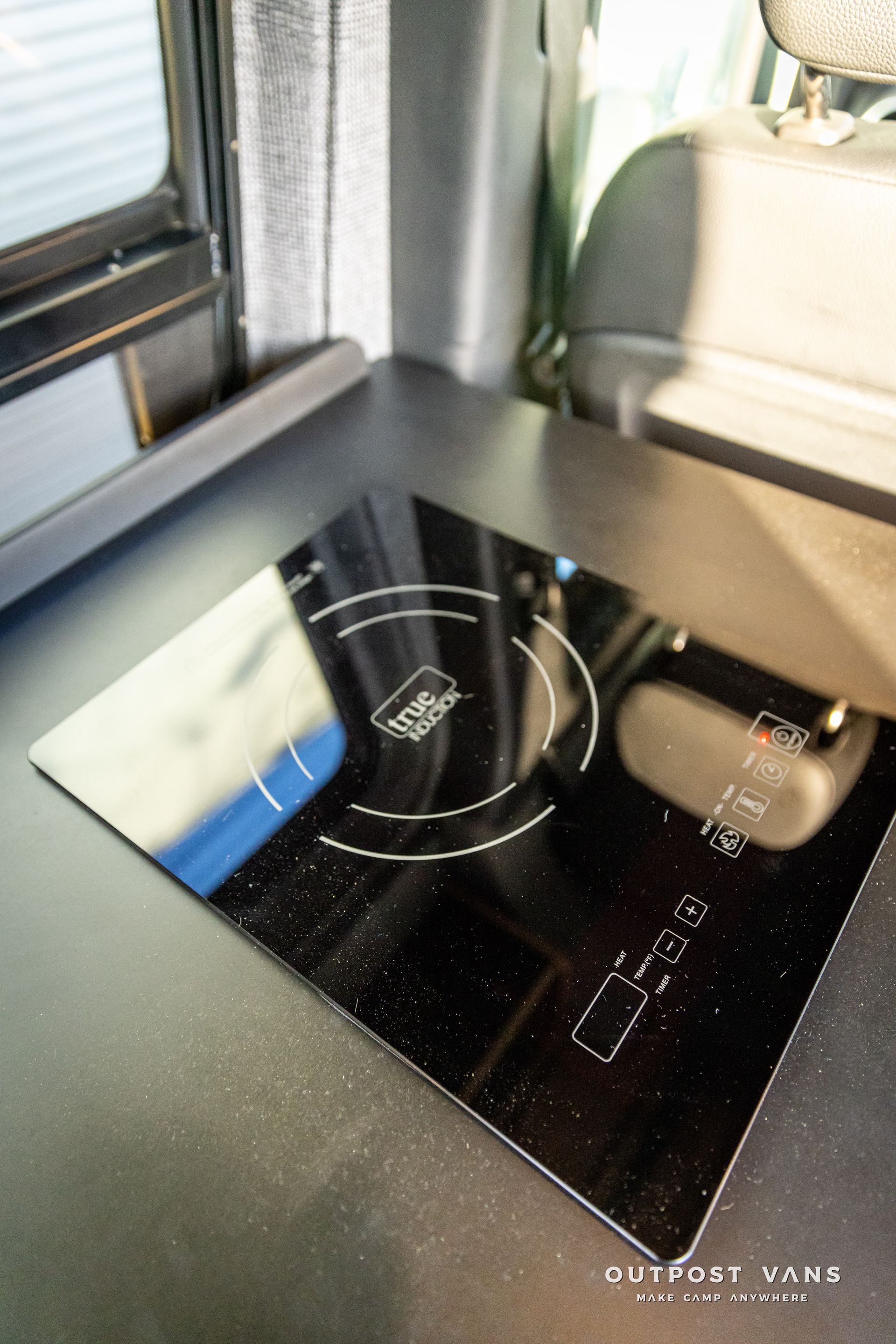 a stove top oven is sitting on a counter in a van .