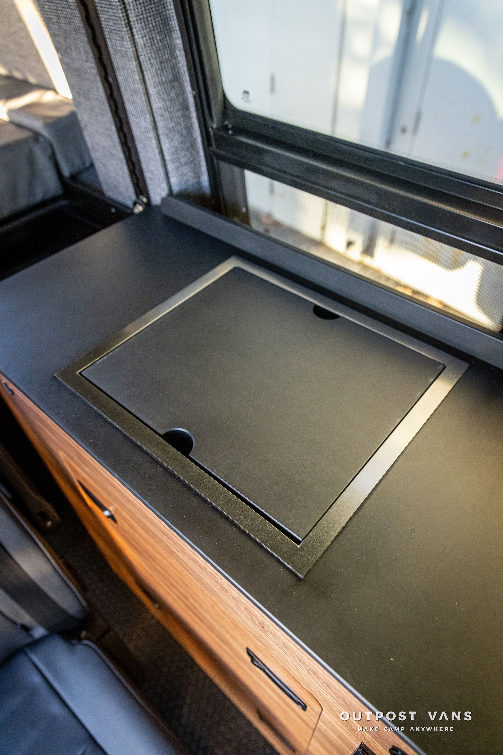 a black counter top with a window in the background .