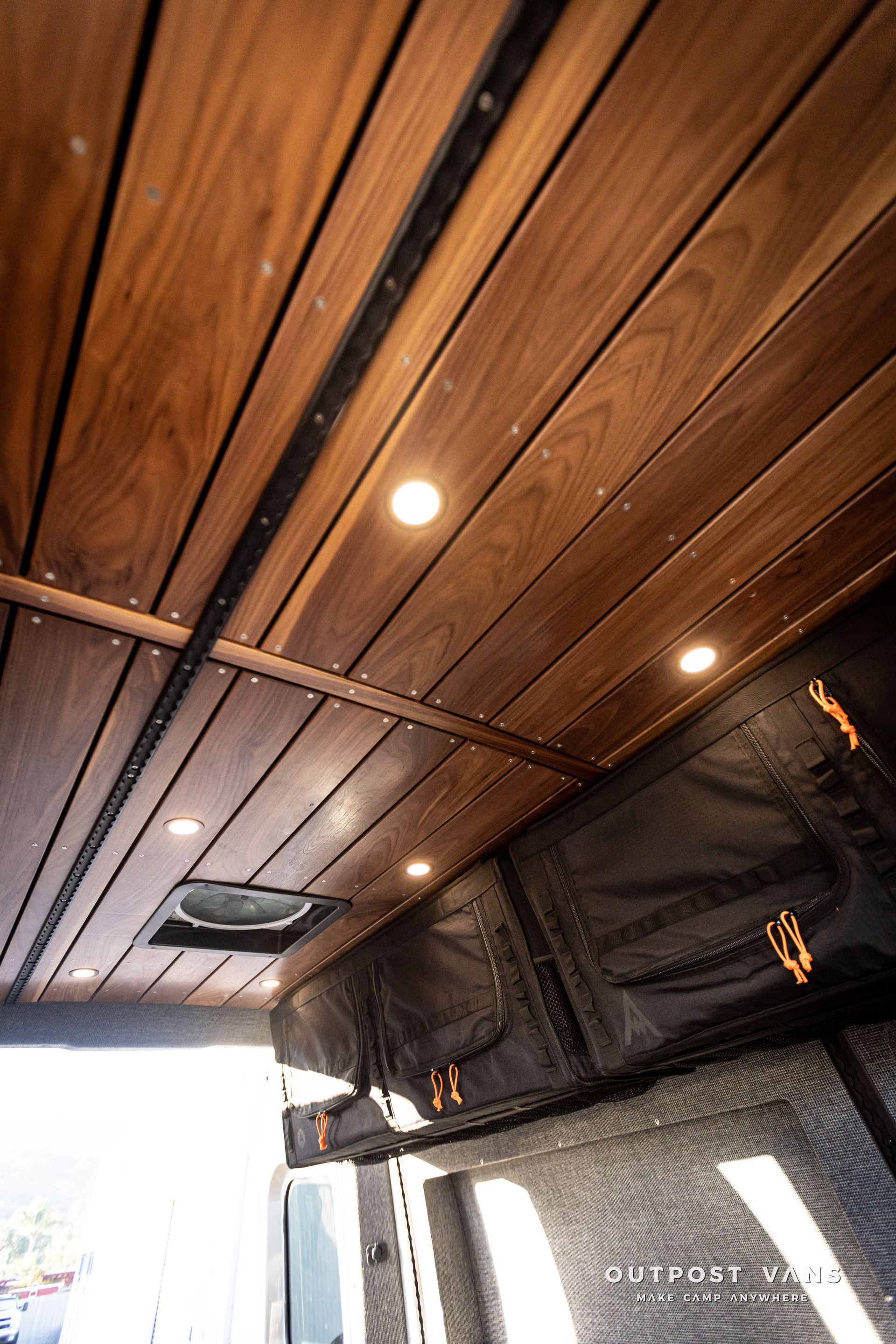 the ceiling of a van is made of wood and has a fan .