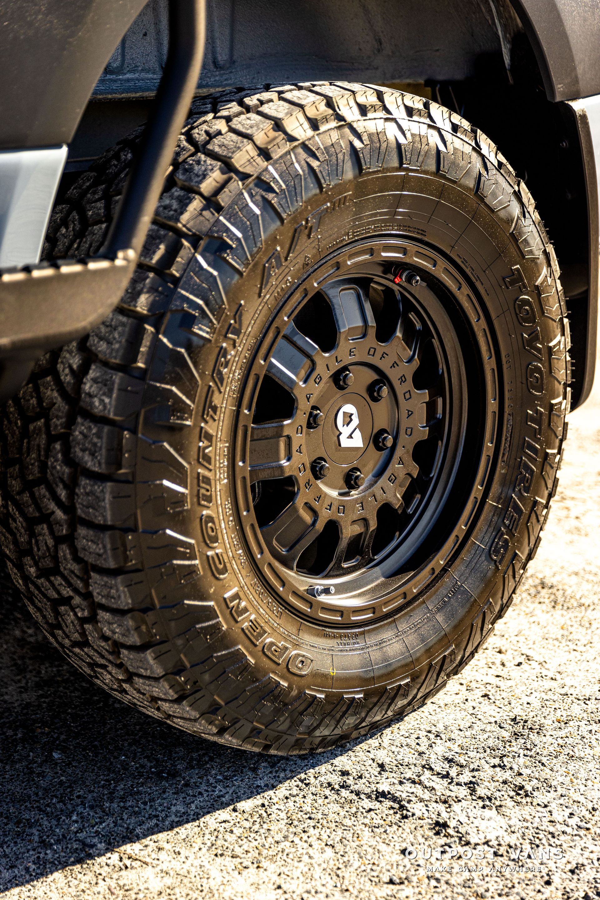 a close up of a tire on a car on a gravel road .