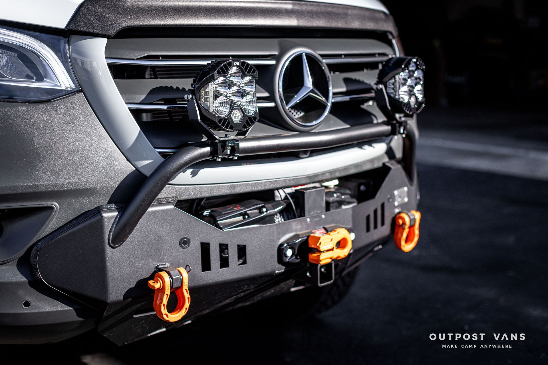 the front bumper of a mercedes sprinter van with a winch attached to it .