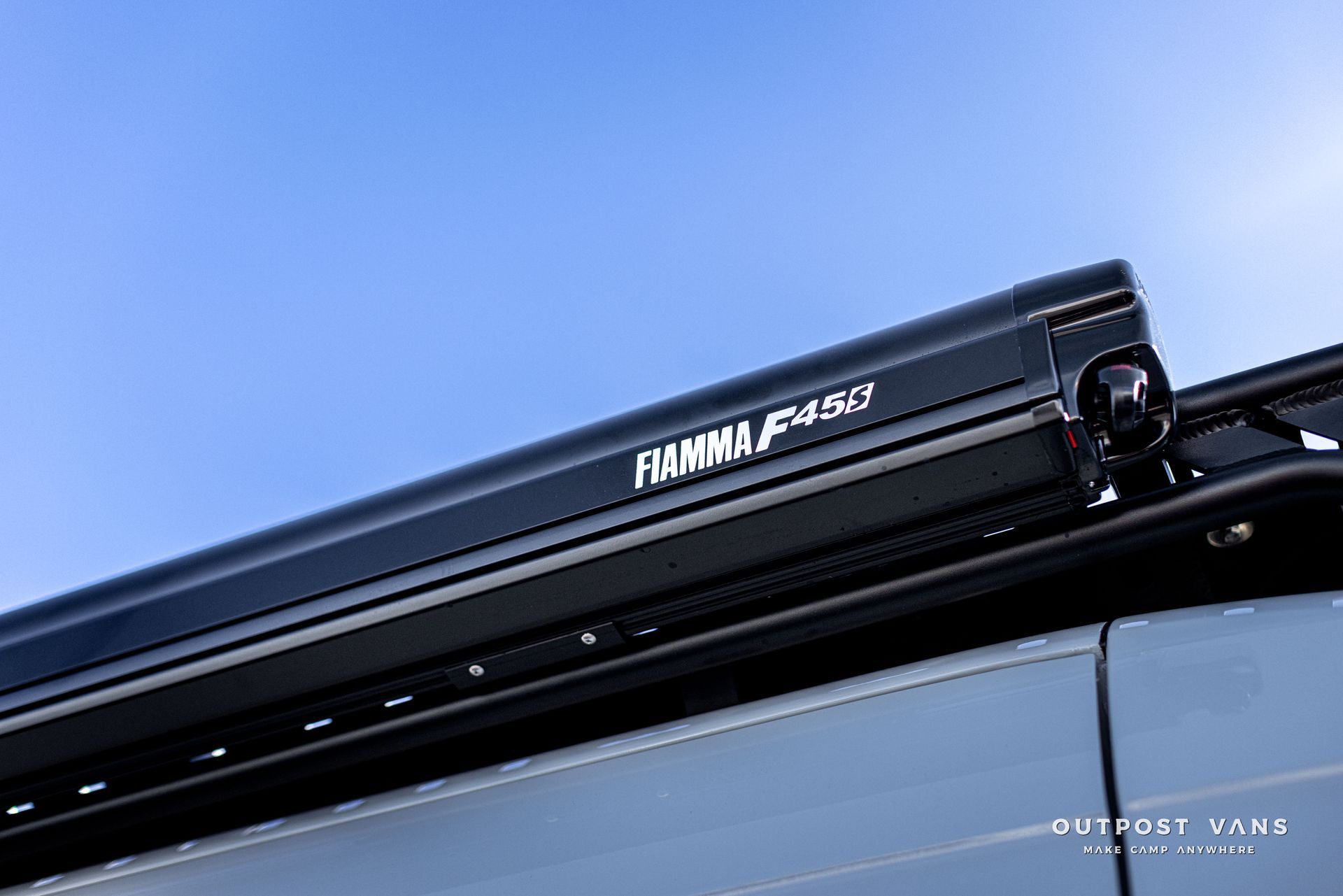 a black awning is attached to the roof of a vehicle .