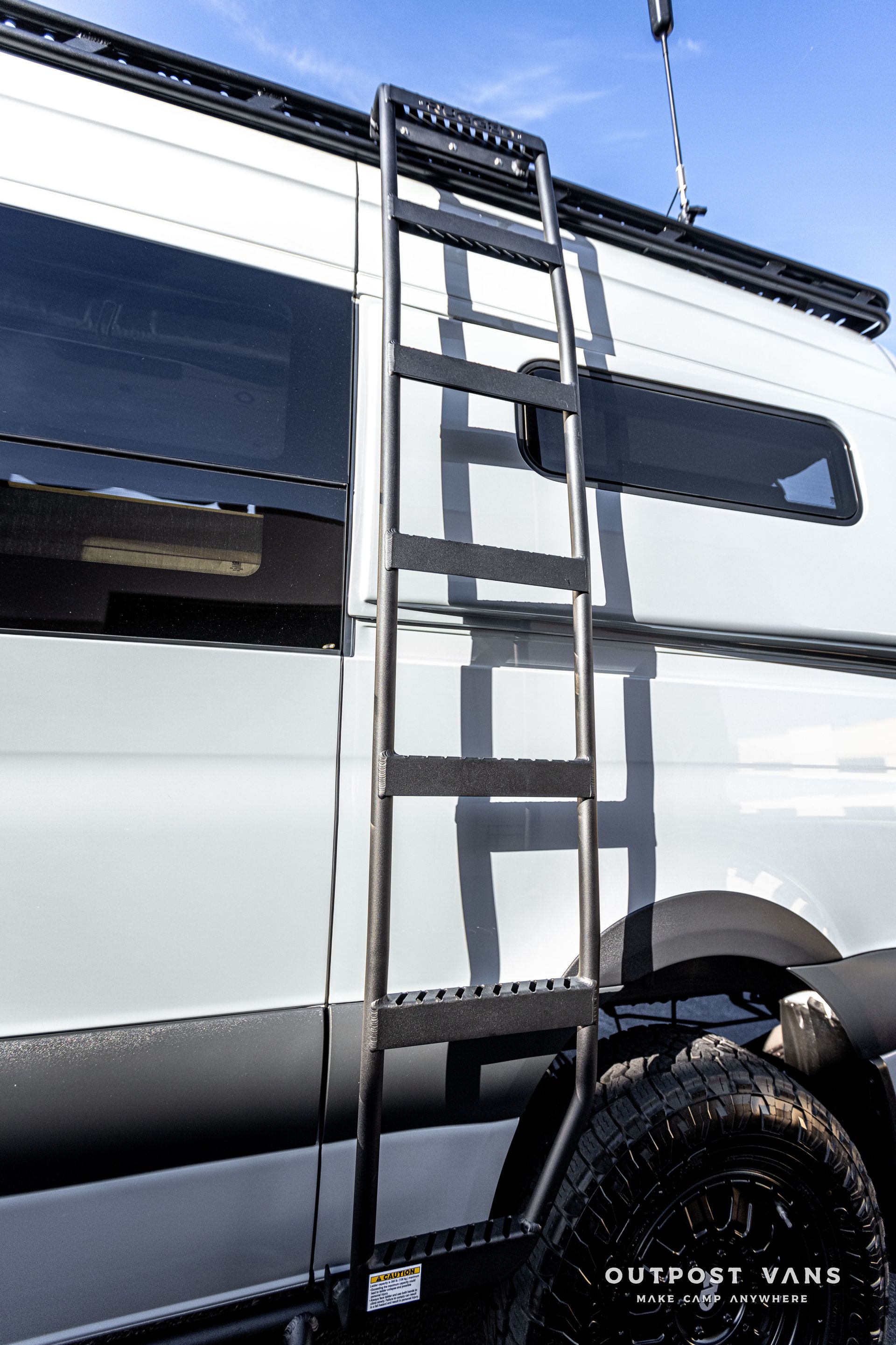 a white van with a ladder attached to the side of it .