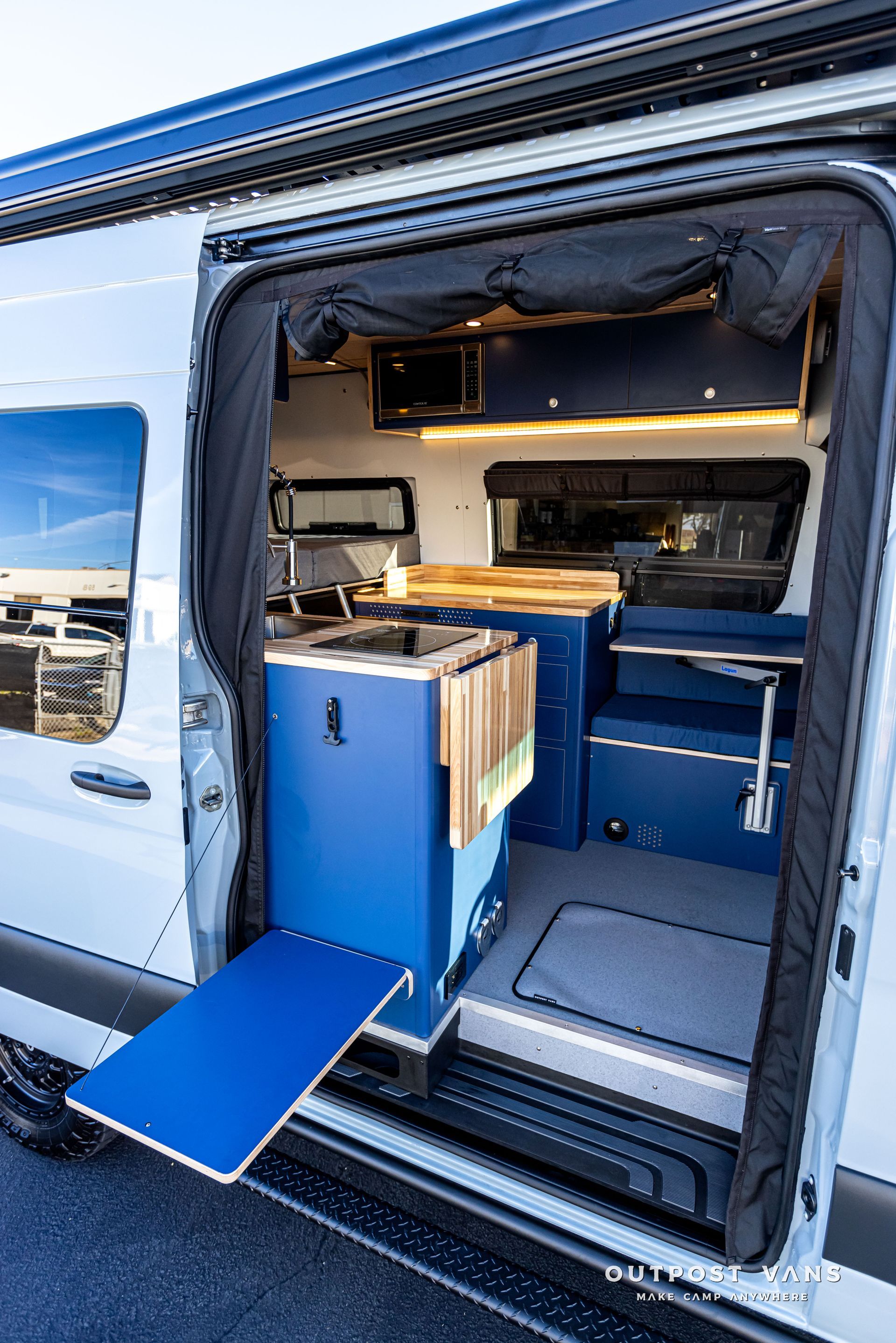 The back of a van with the door open and a blue table.