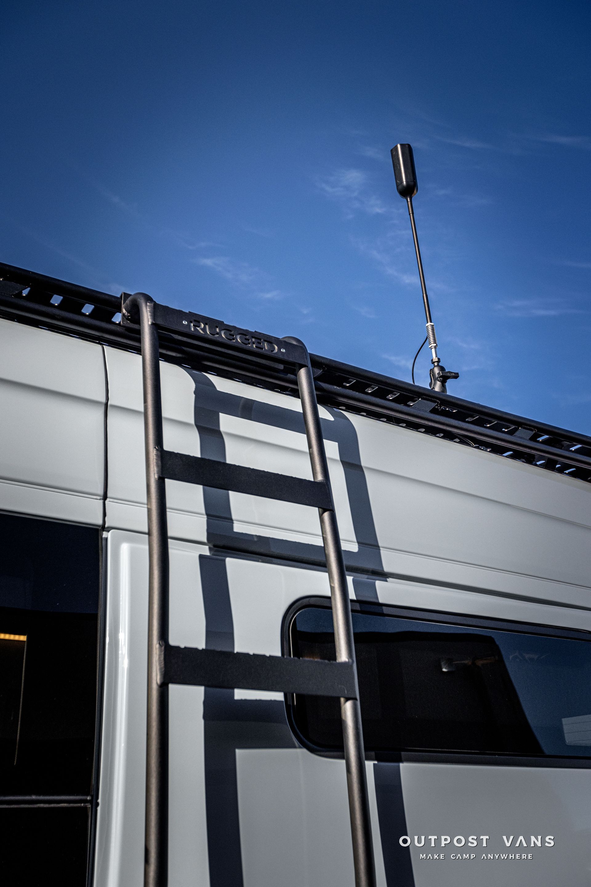 a ladder is attached to the side of a van .