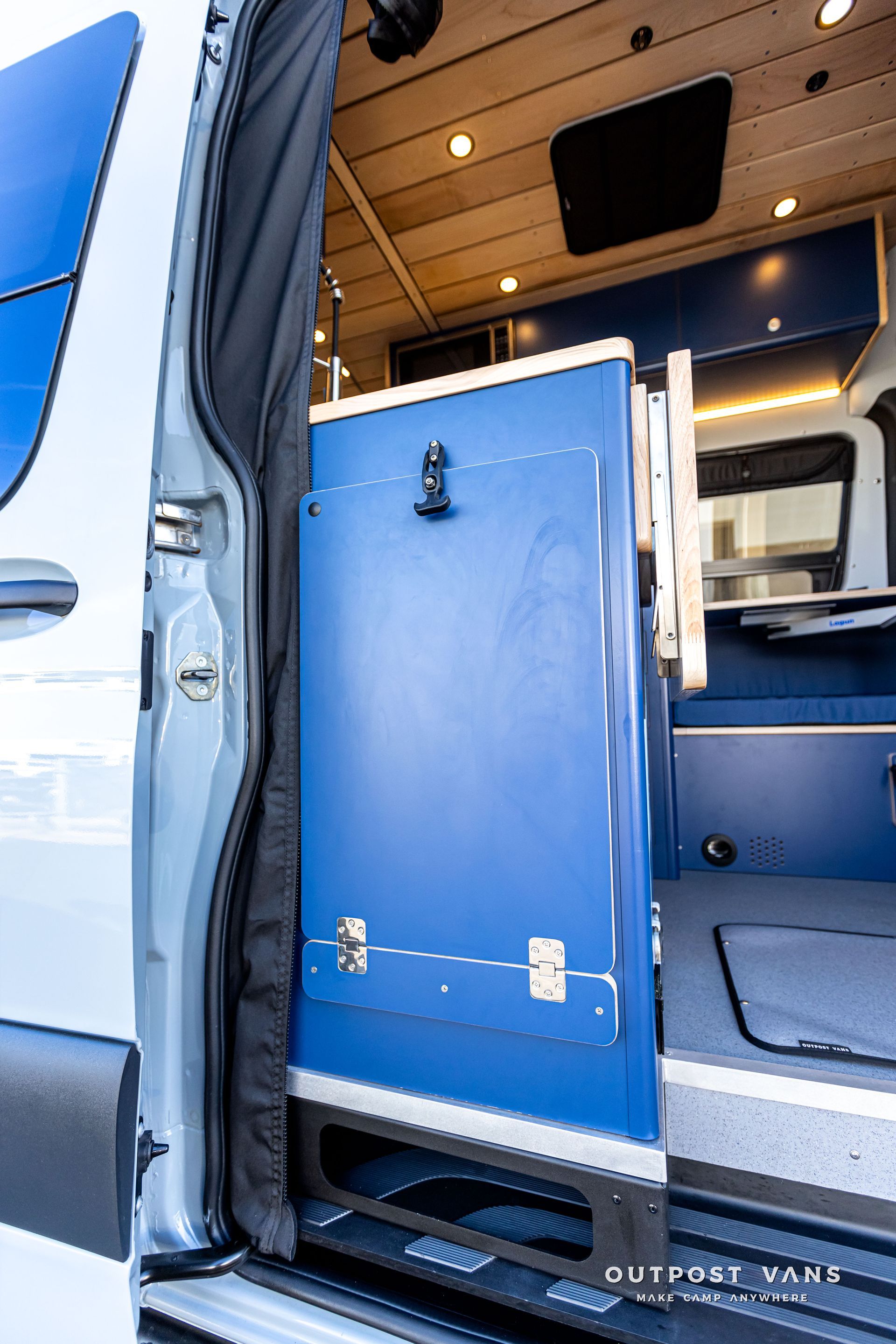 A white van with a blue cabinet in the back of it.