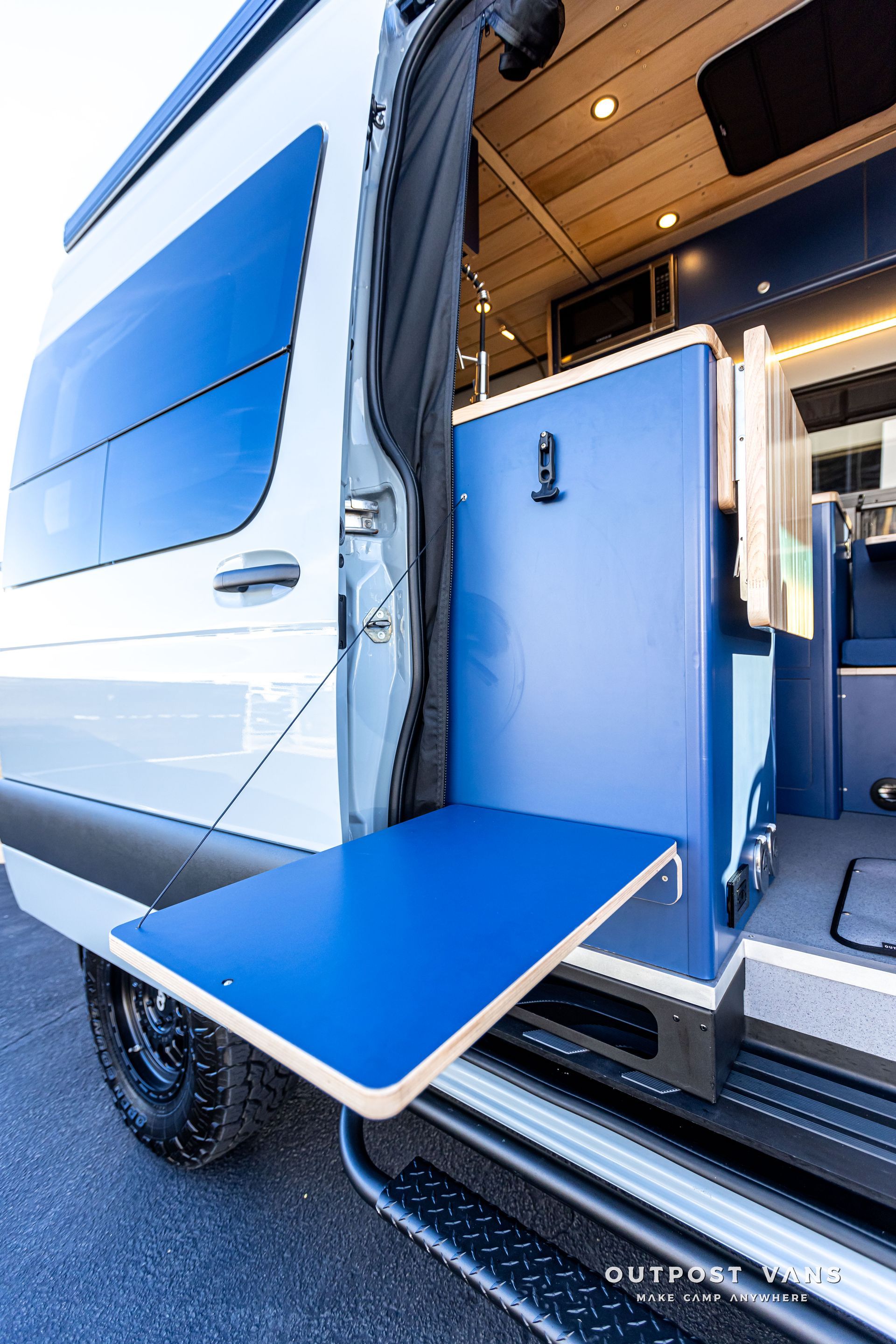 A white van with a blue table in the back of it.