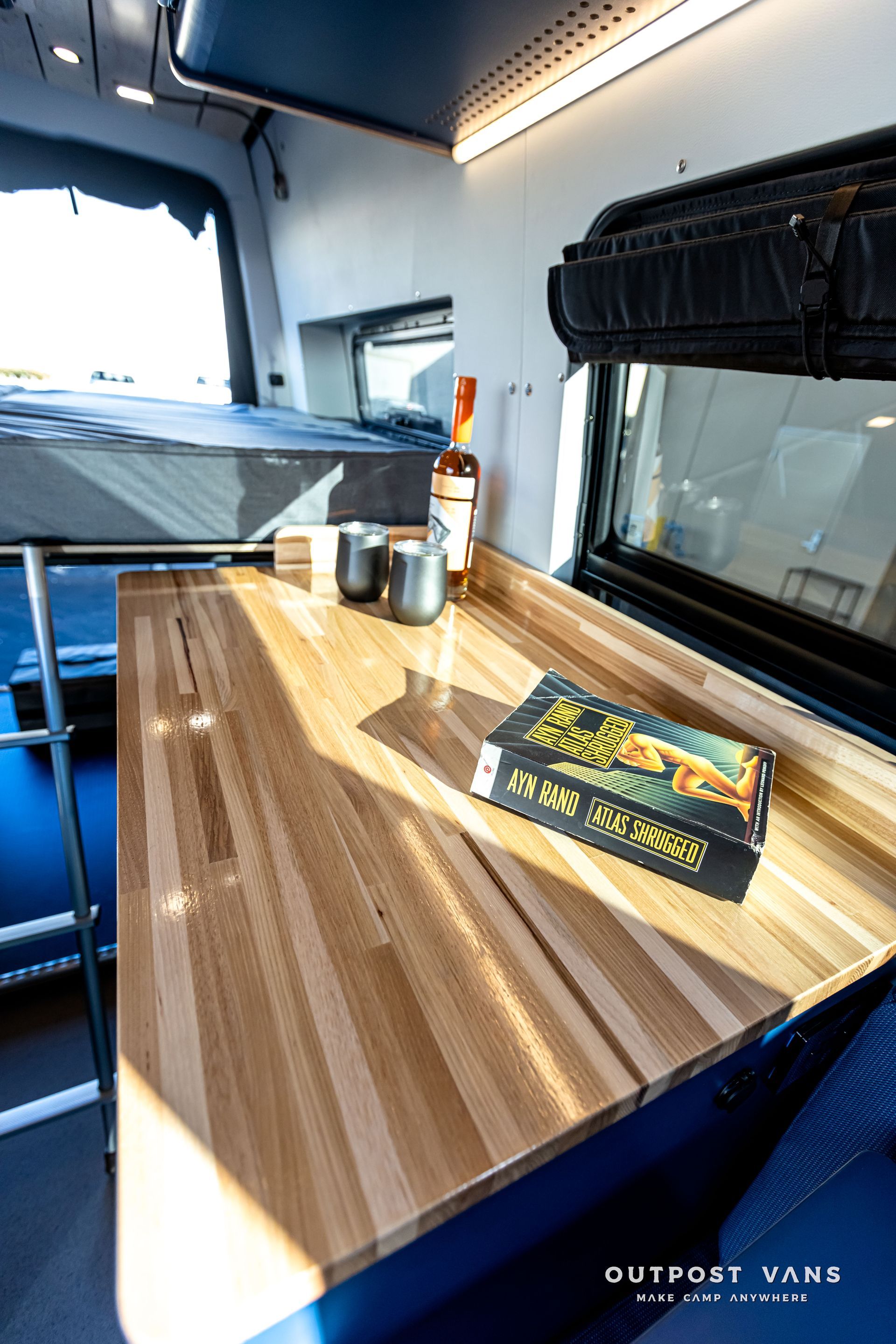 A wooden table with a book on it in a van.