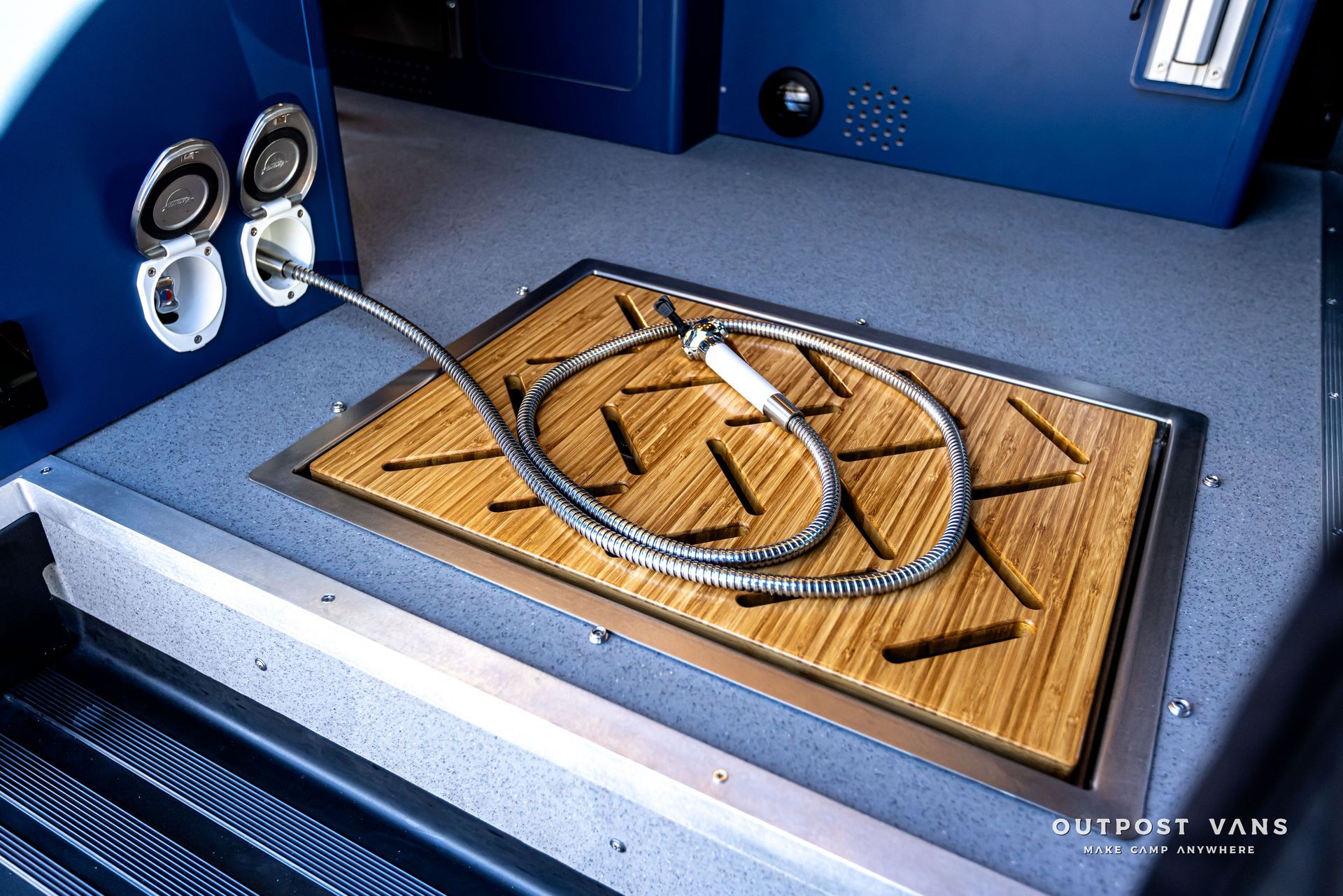 A hose is laying on a wooden mat that says outpost tank