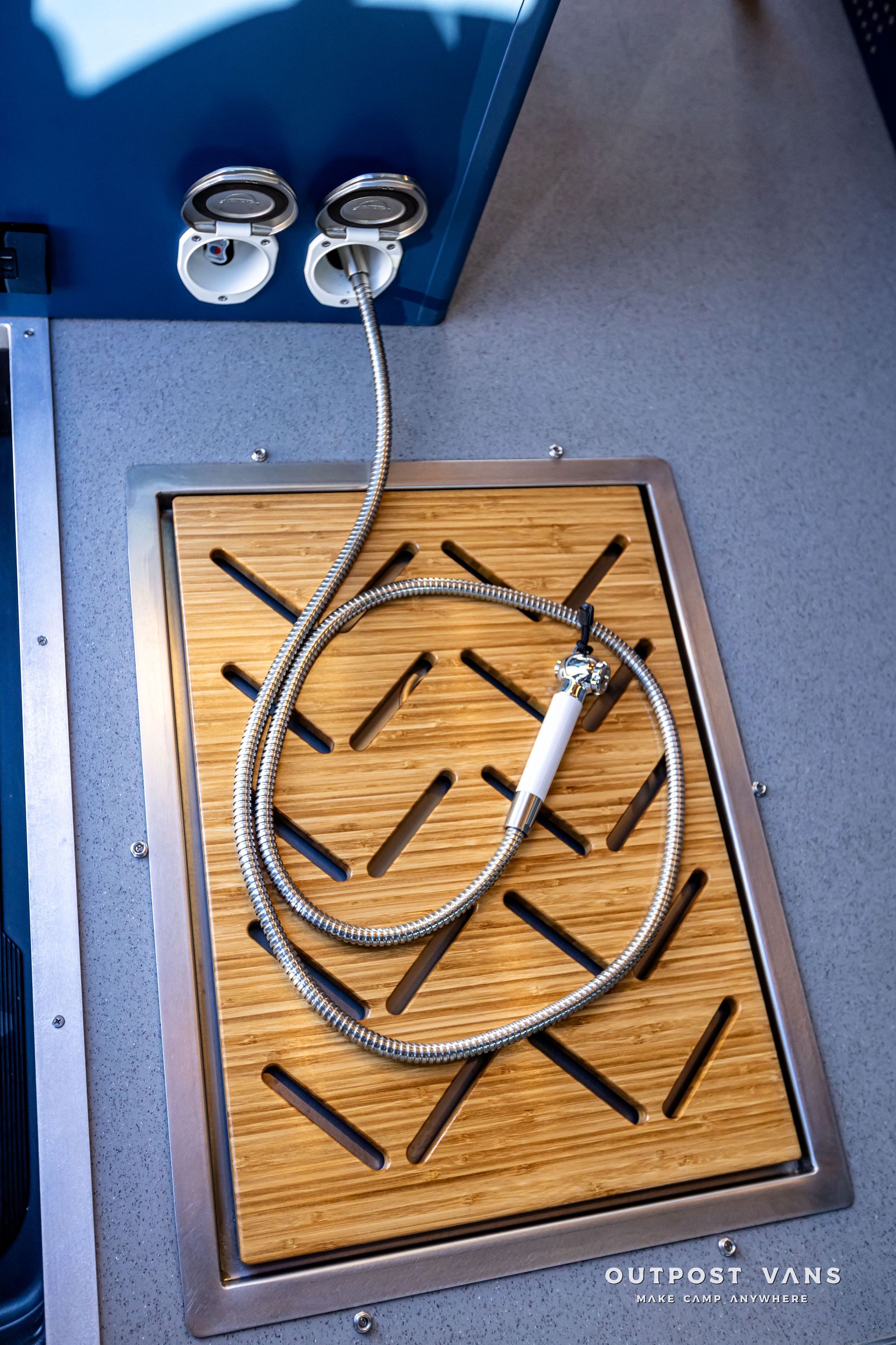 A shower head is sitting on top of a wooden mat