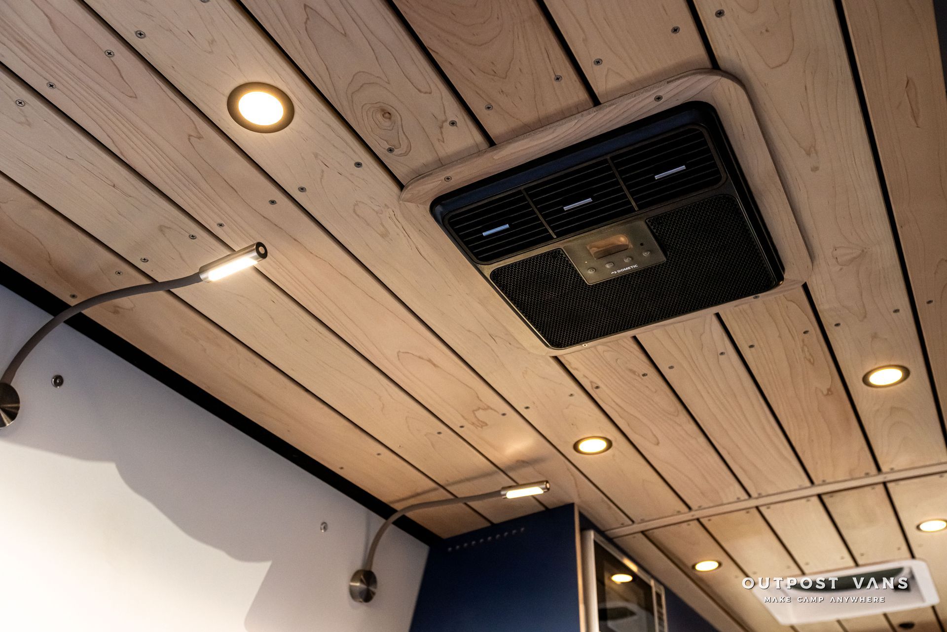 A wooden ceiling with a fan and lights on it