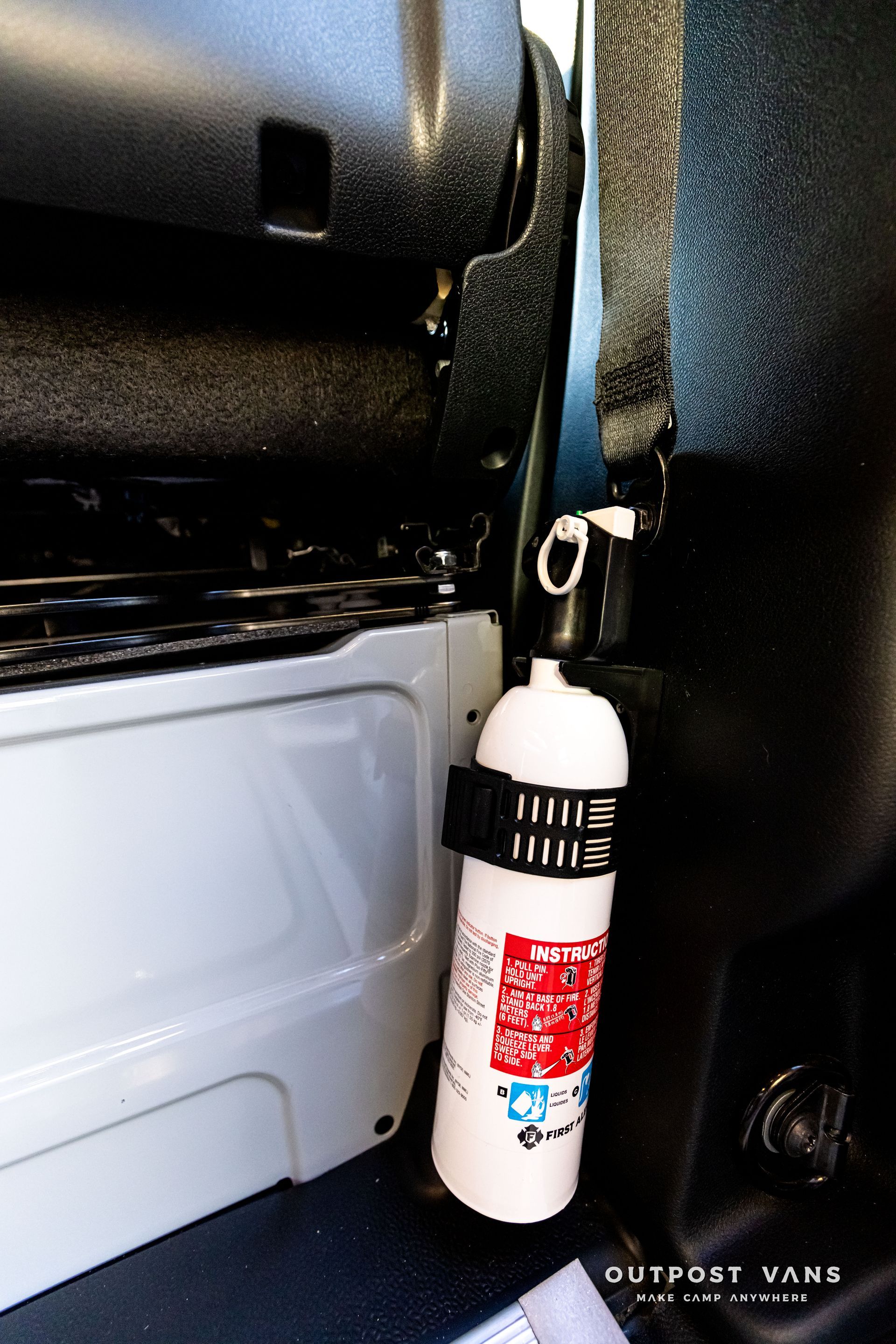 A fire extinguisher is attached to the side of a van