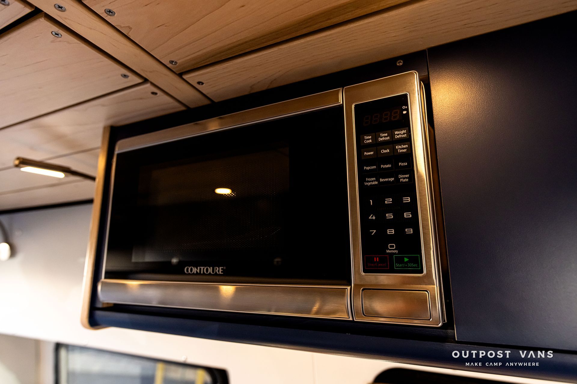 A stainless steel microwave with the word outpost on the bottom