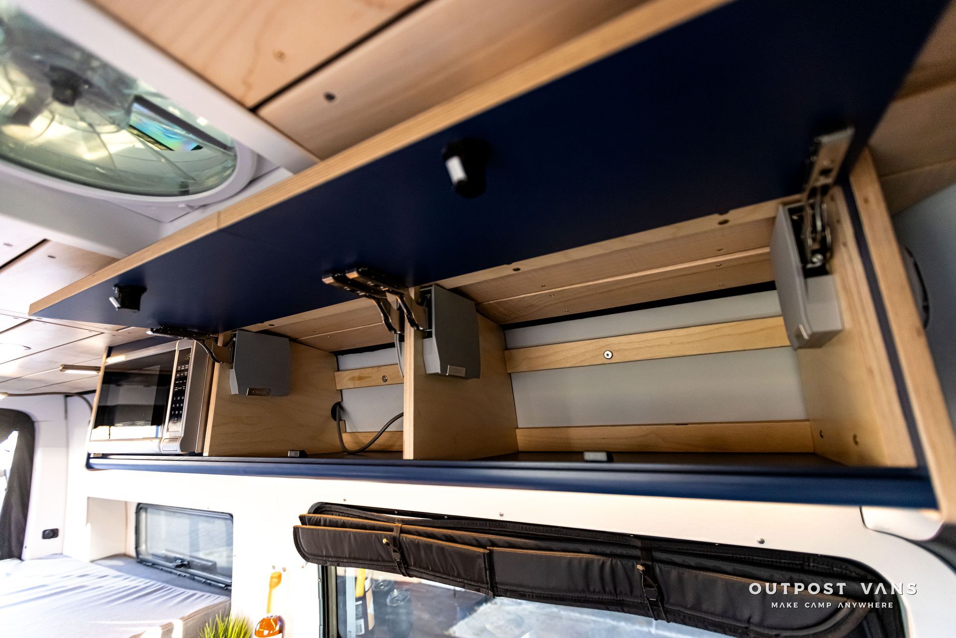 The ceiling of a camper van has a lot of storage space underneath it.