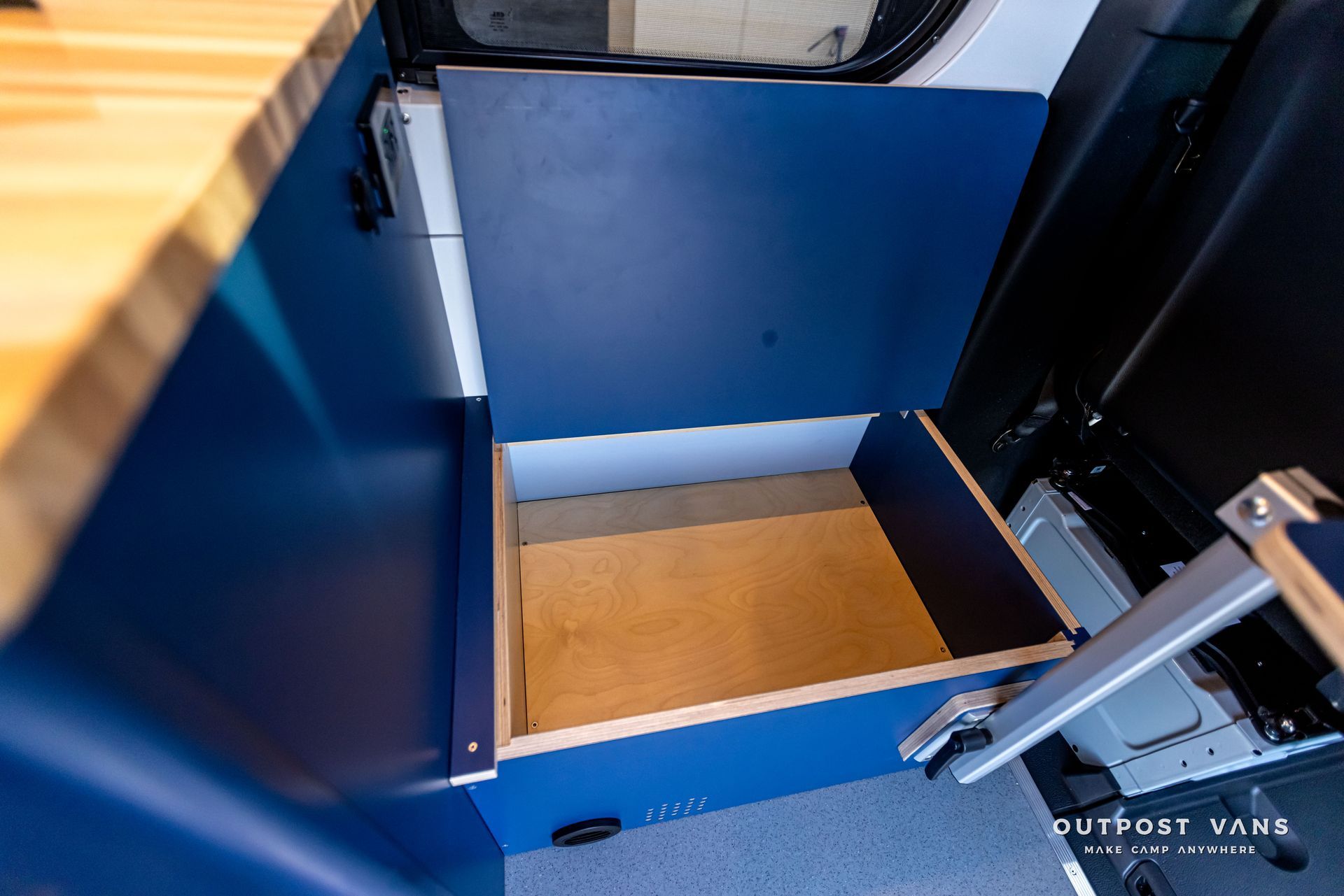 A blue cabinet with a wooden drawer underneath it