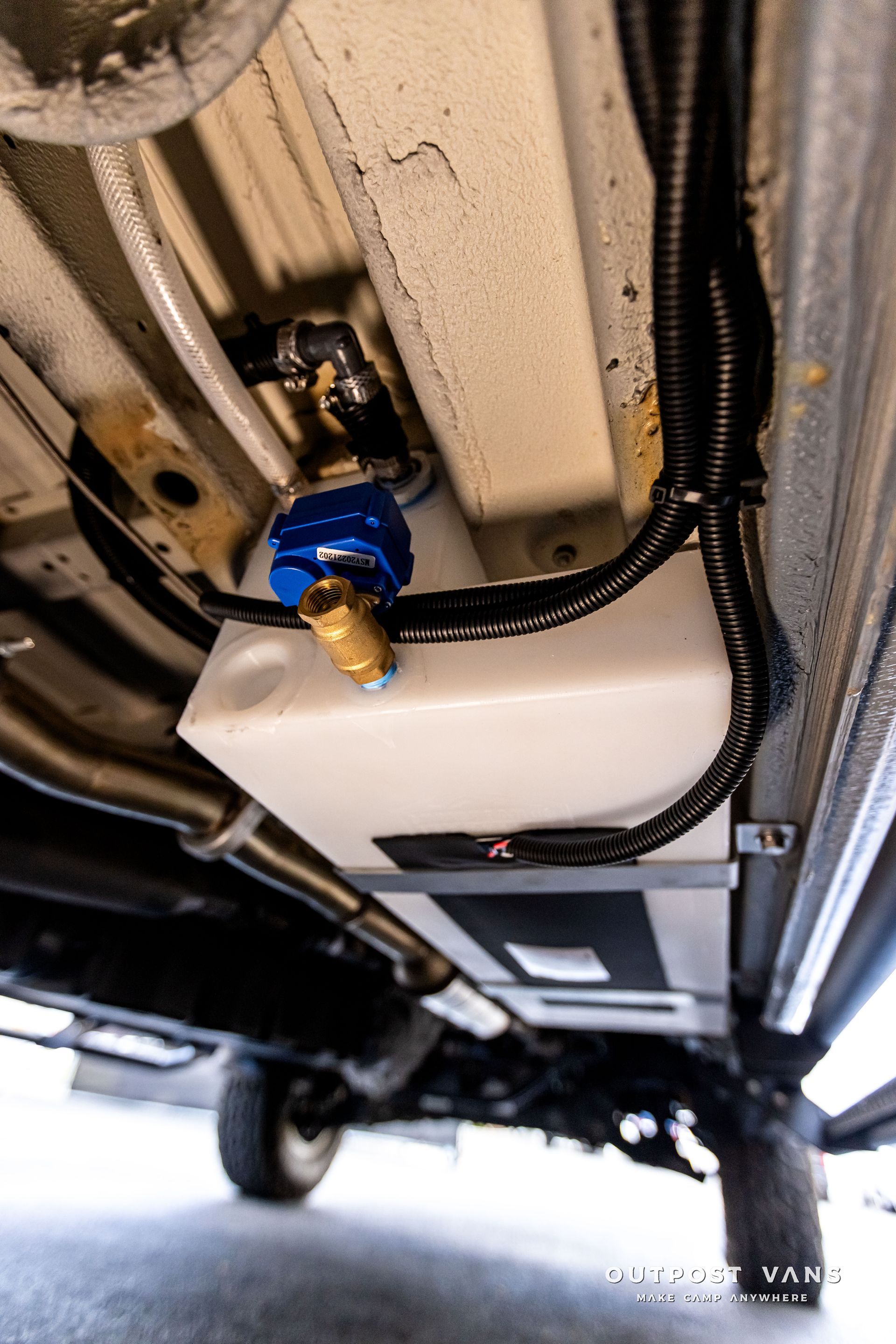 a water tank is attached to the underside of a truck .