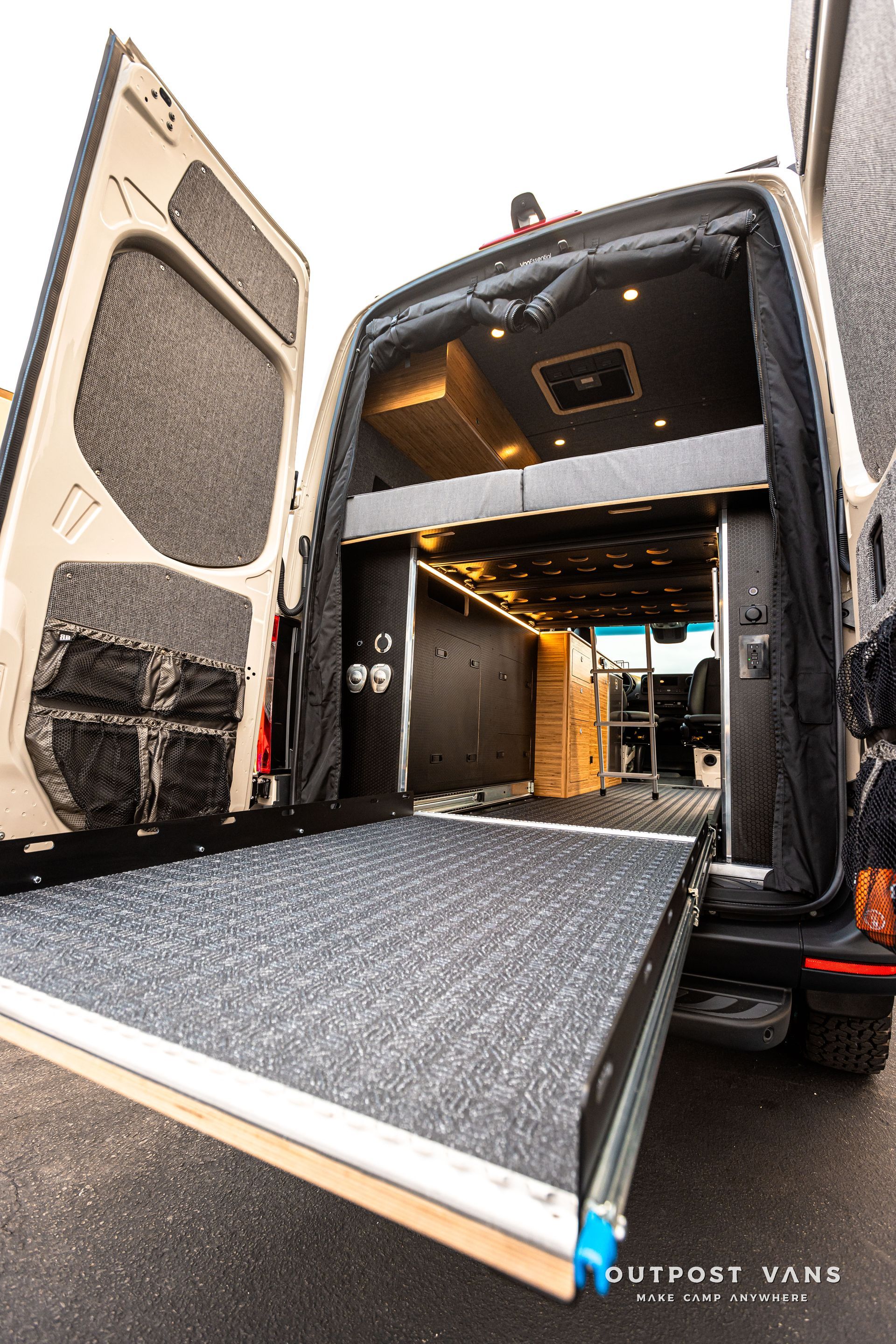 The back of a van with the door open and a ramp.