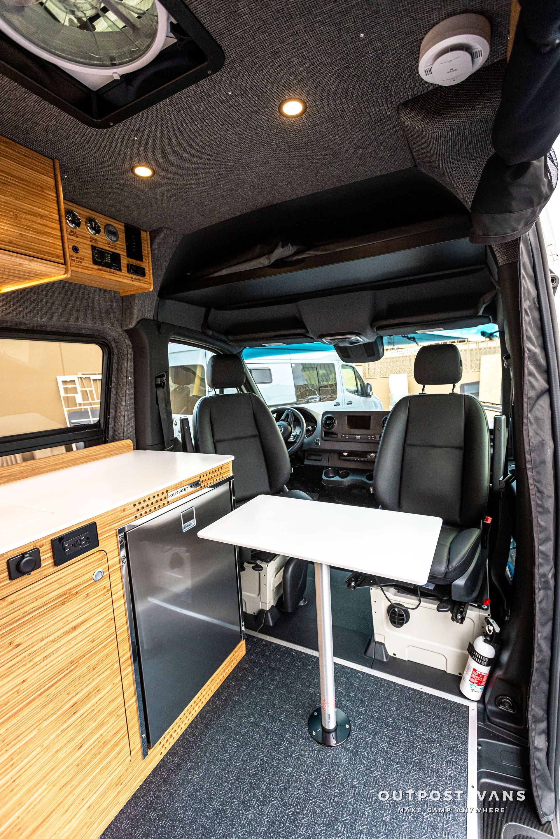 The inside of a van with a table and chairs.