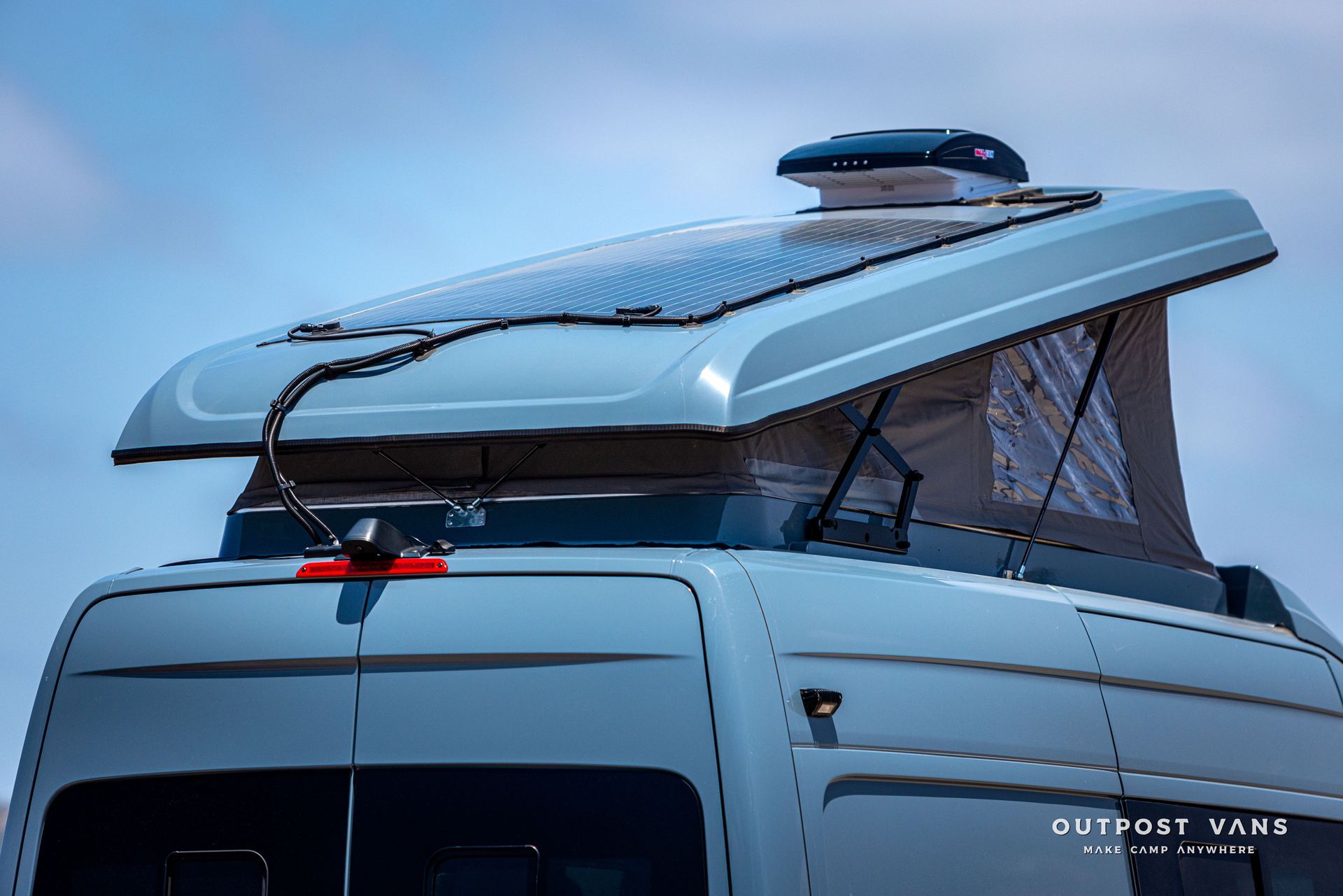 A van with a pop up roof and solar panels on the roof.