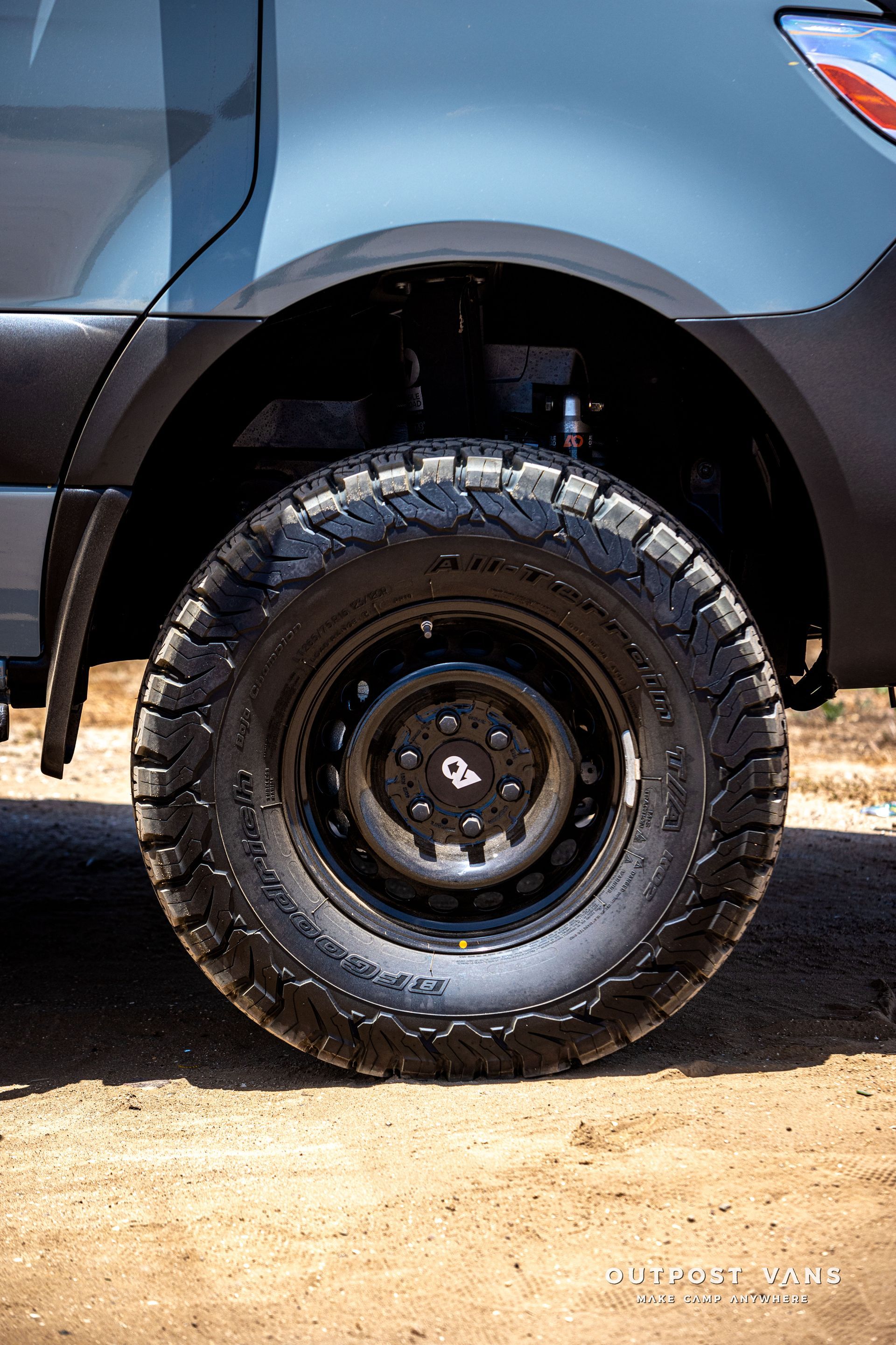 A close up of a truck tire on a dirt road.