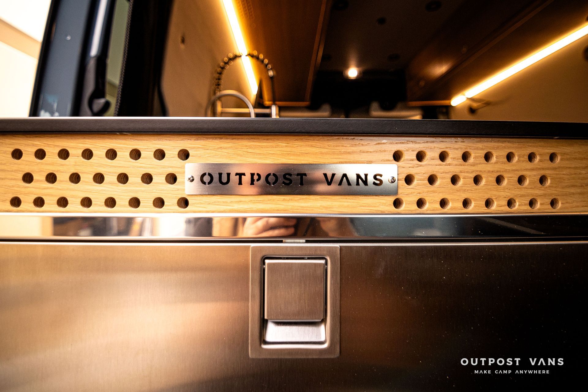 A stainless steel drawer with the word outpost vans on it