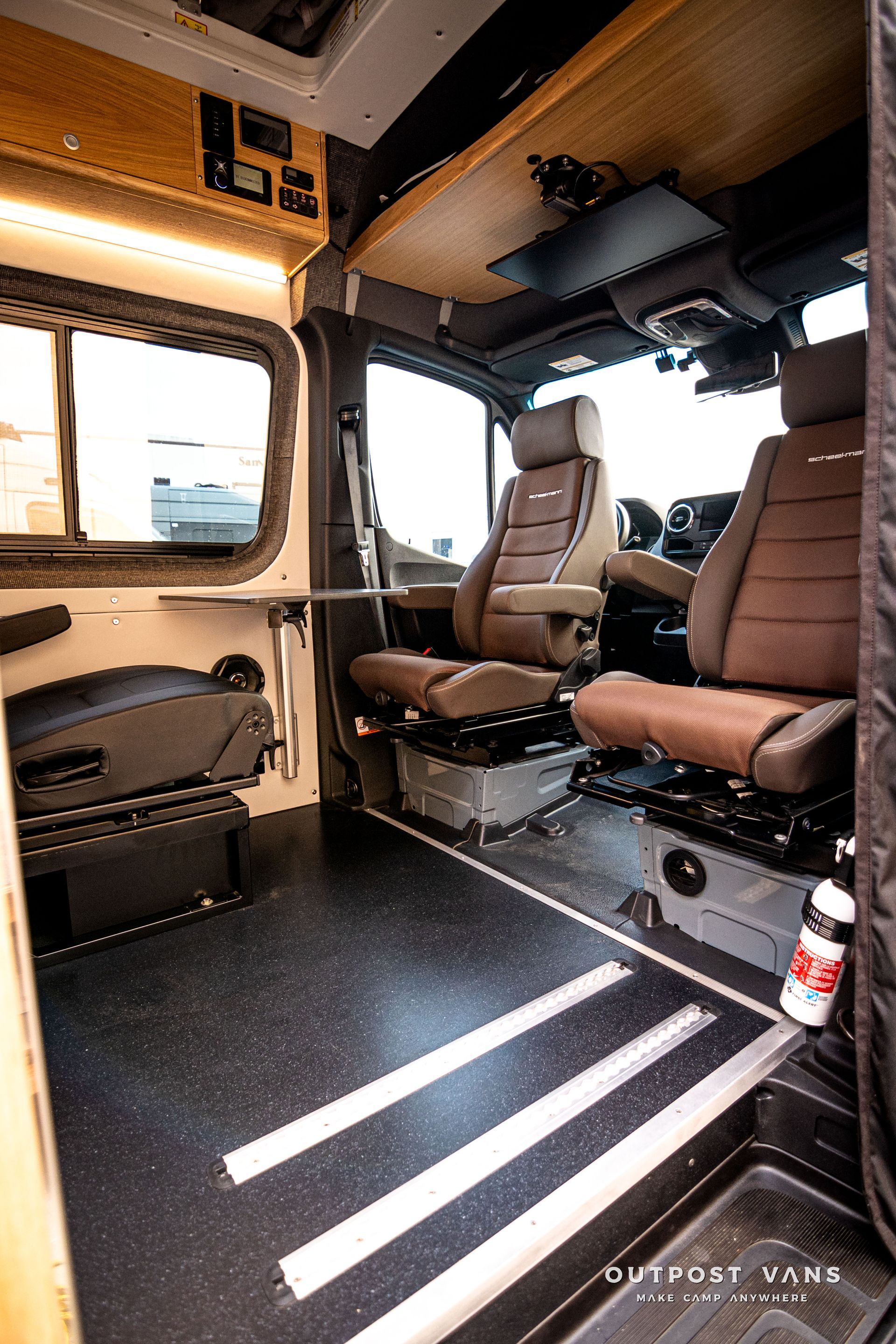 The inside of a van with brown seats and stairs.