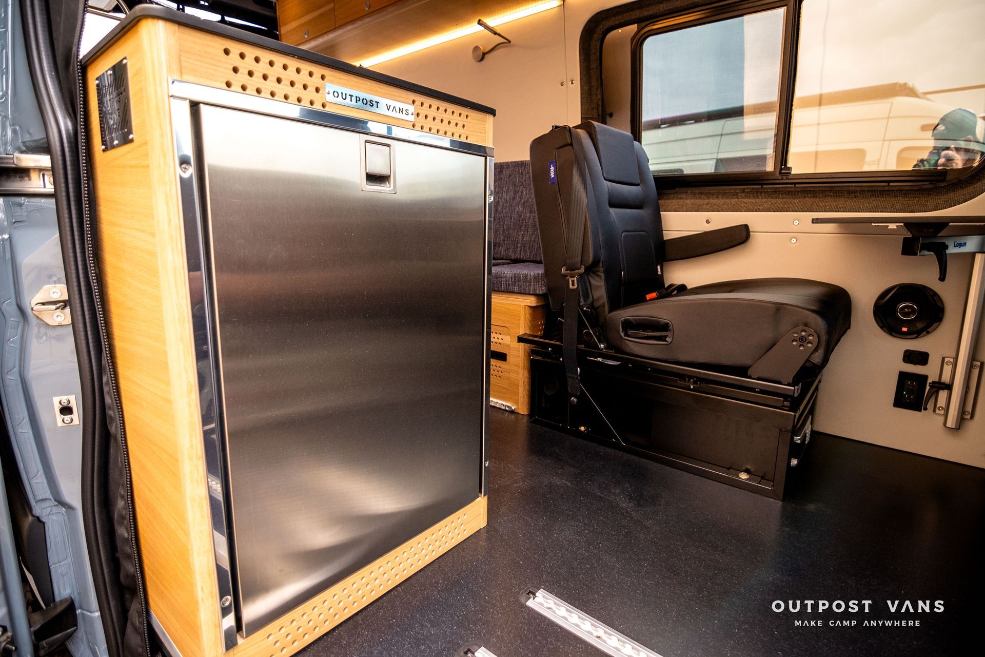 There is a stainless steel refrigerator in the back of the van.