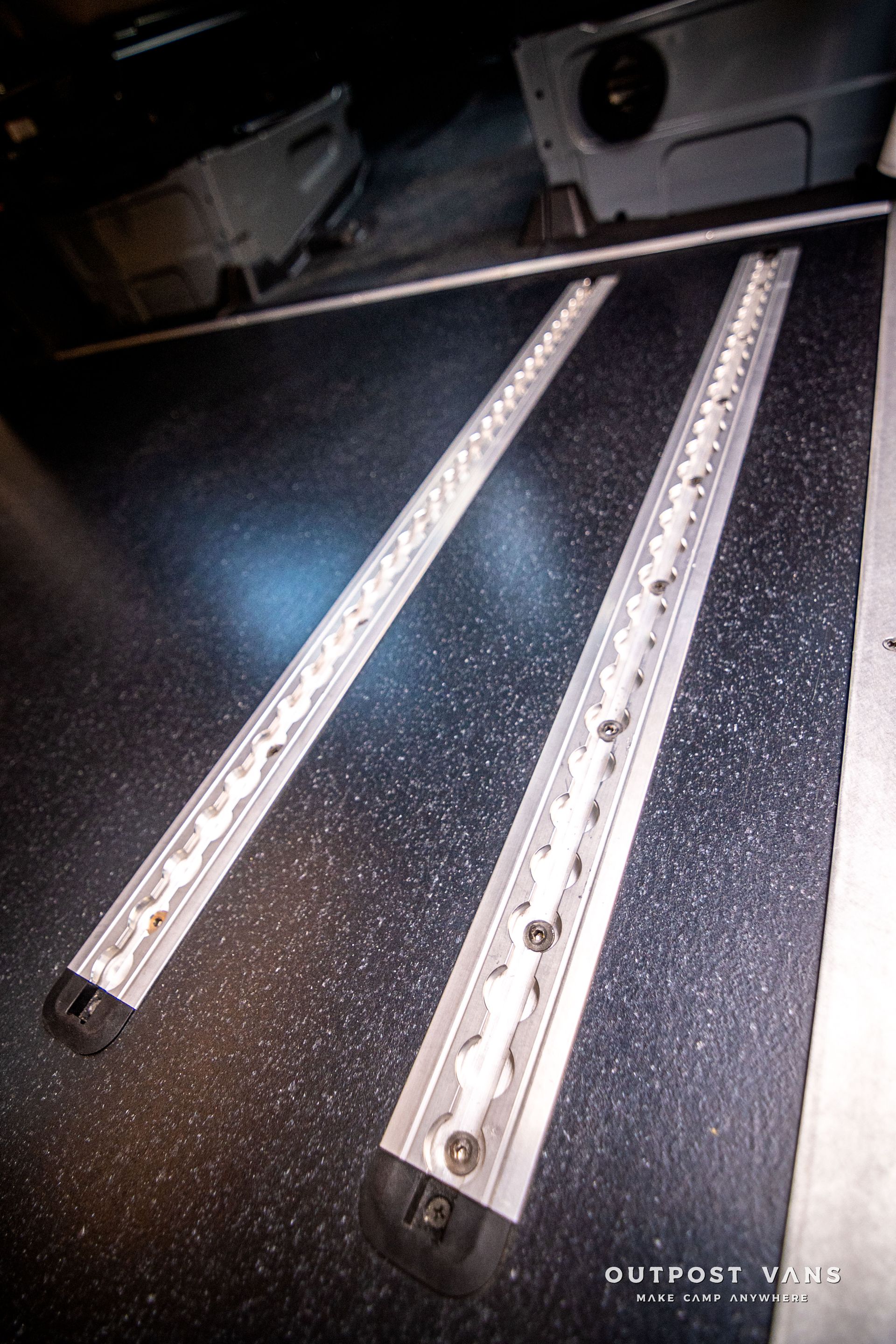 A pair of metal rails are sitting on a black surface.