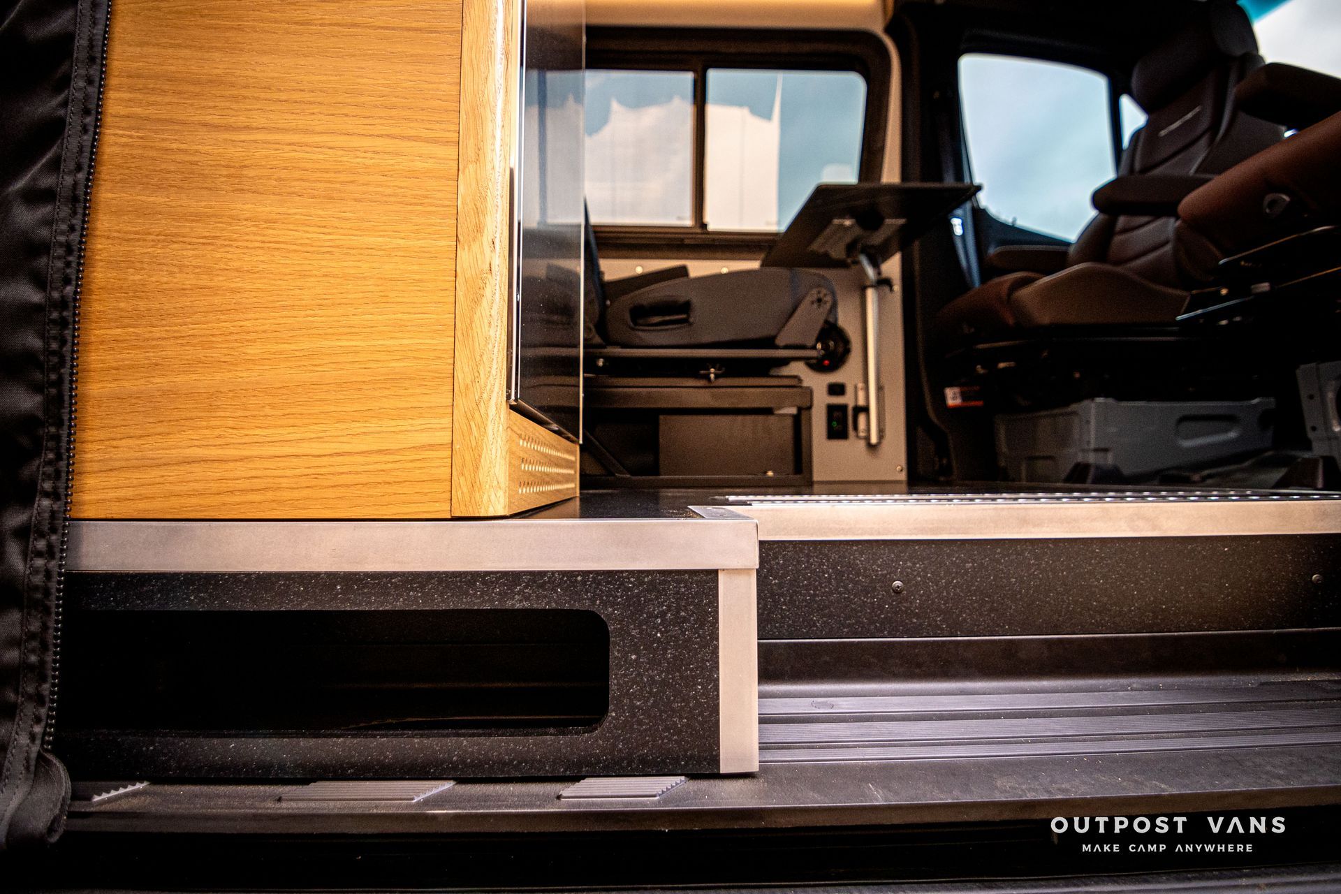 A man is sitting in the back seat of a van.