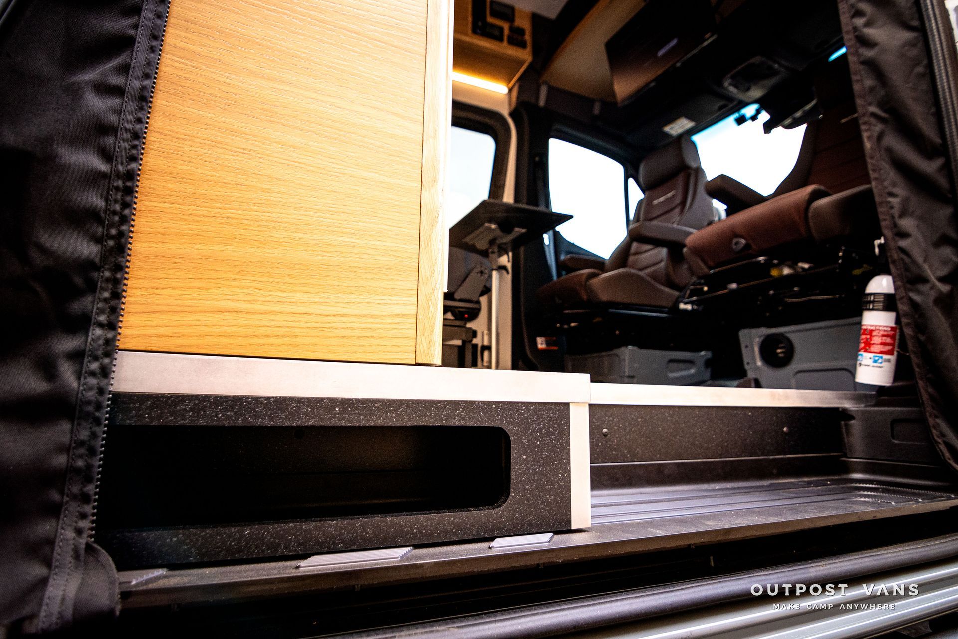 The inside of a camper van with a table and chairs.