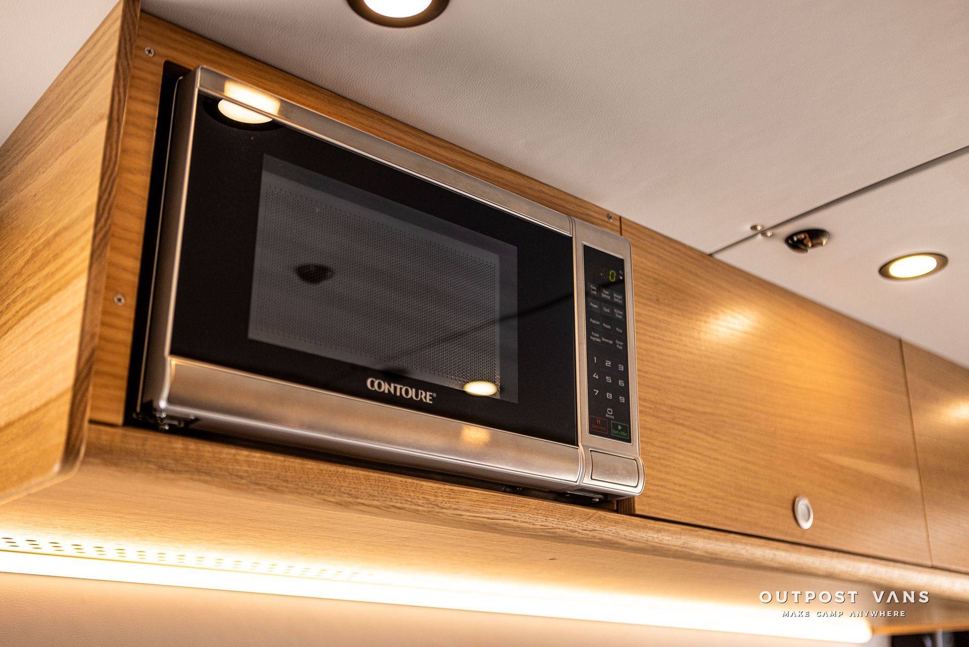 A microwave oven is sitting on top of a wooden cabinet.
