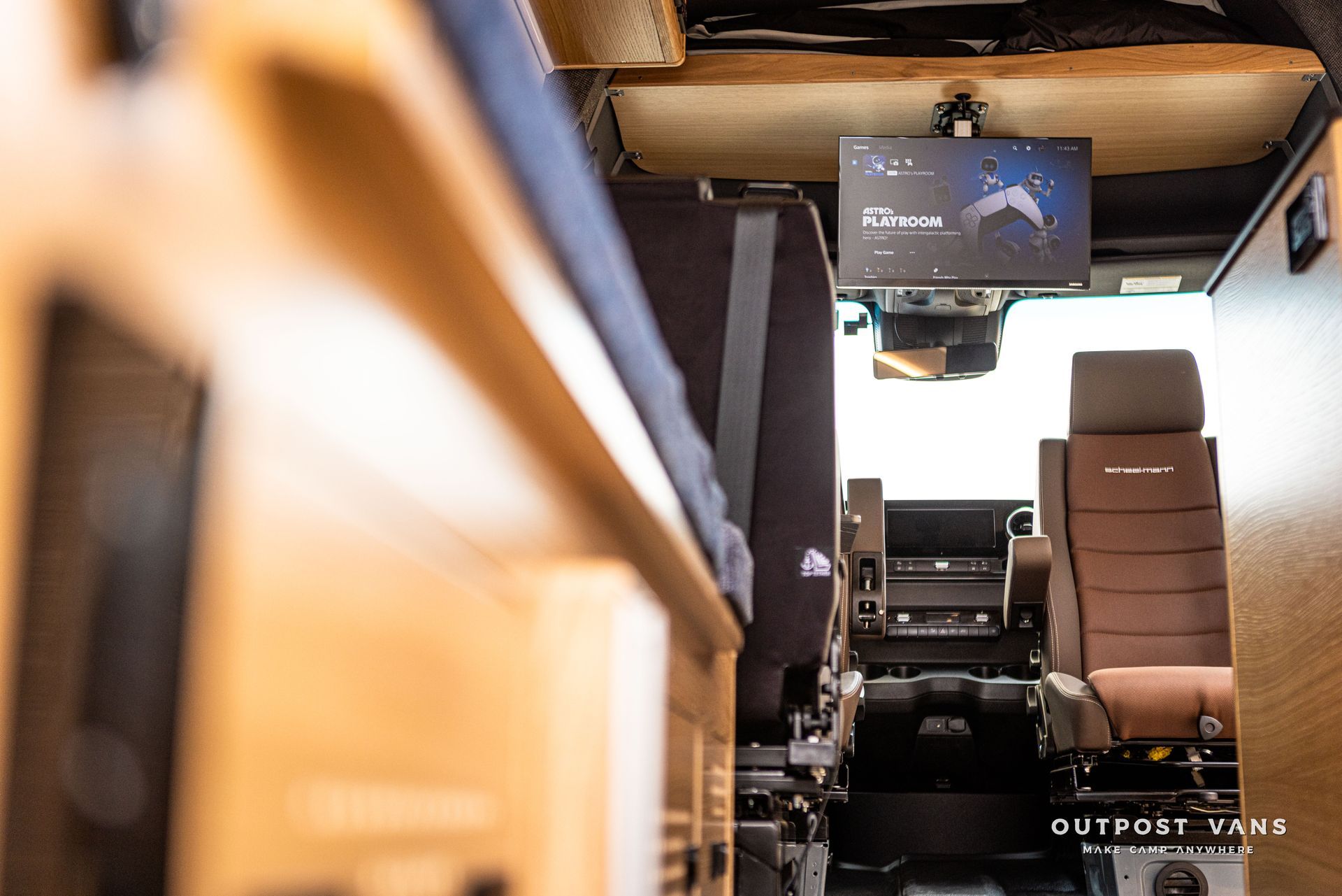 A camper van with a tv mounted to the ceiling.