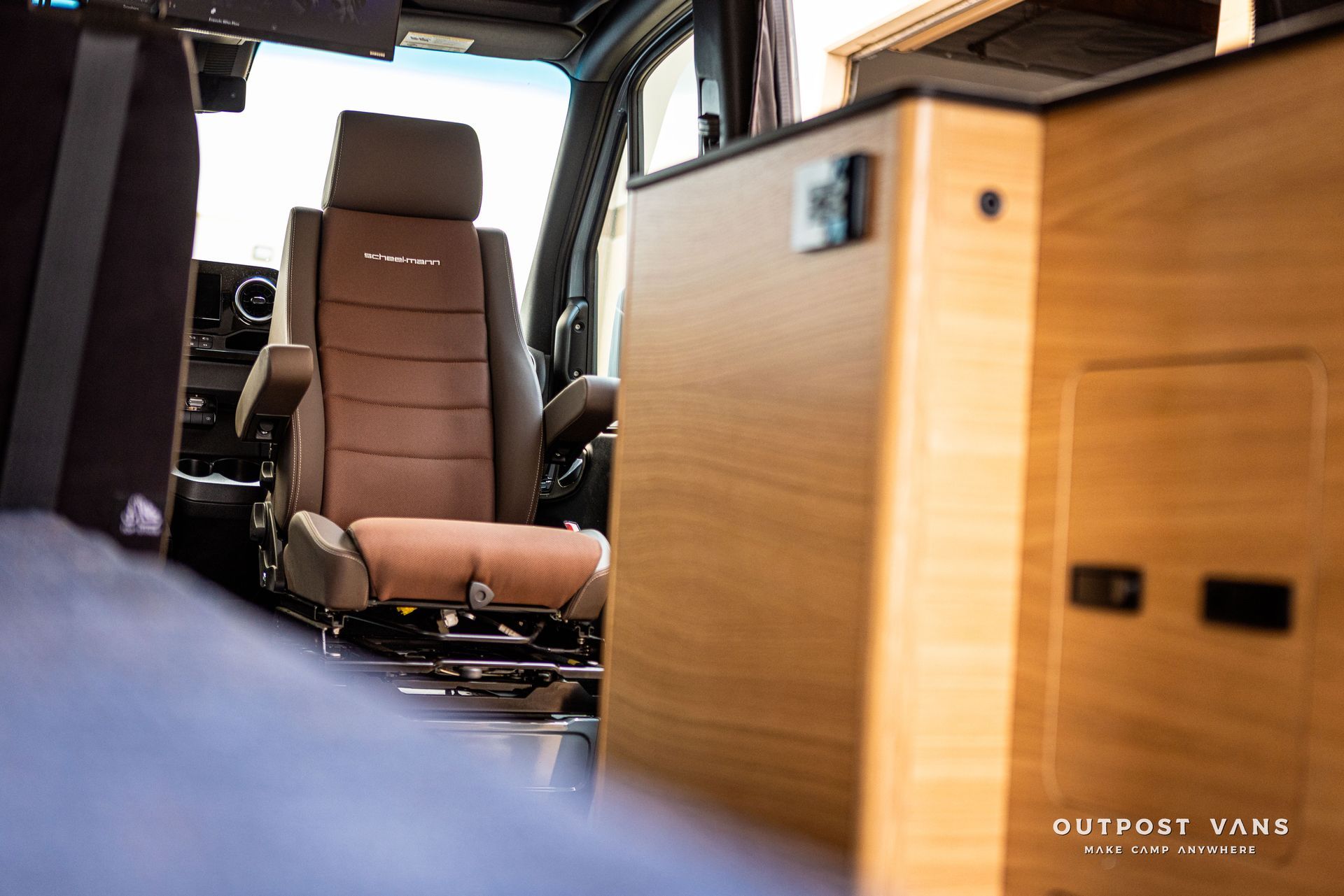 A car with a brown seat and a wooden cabinet.