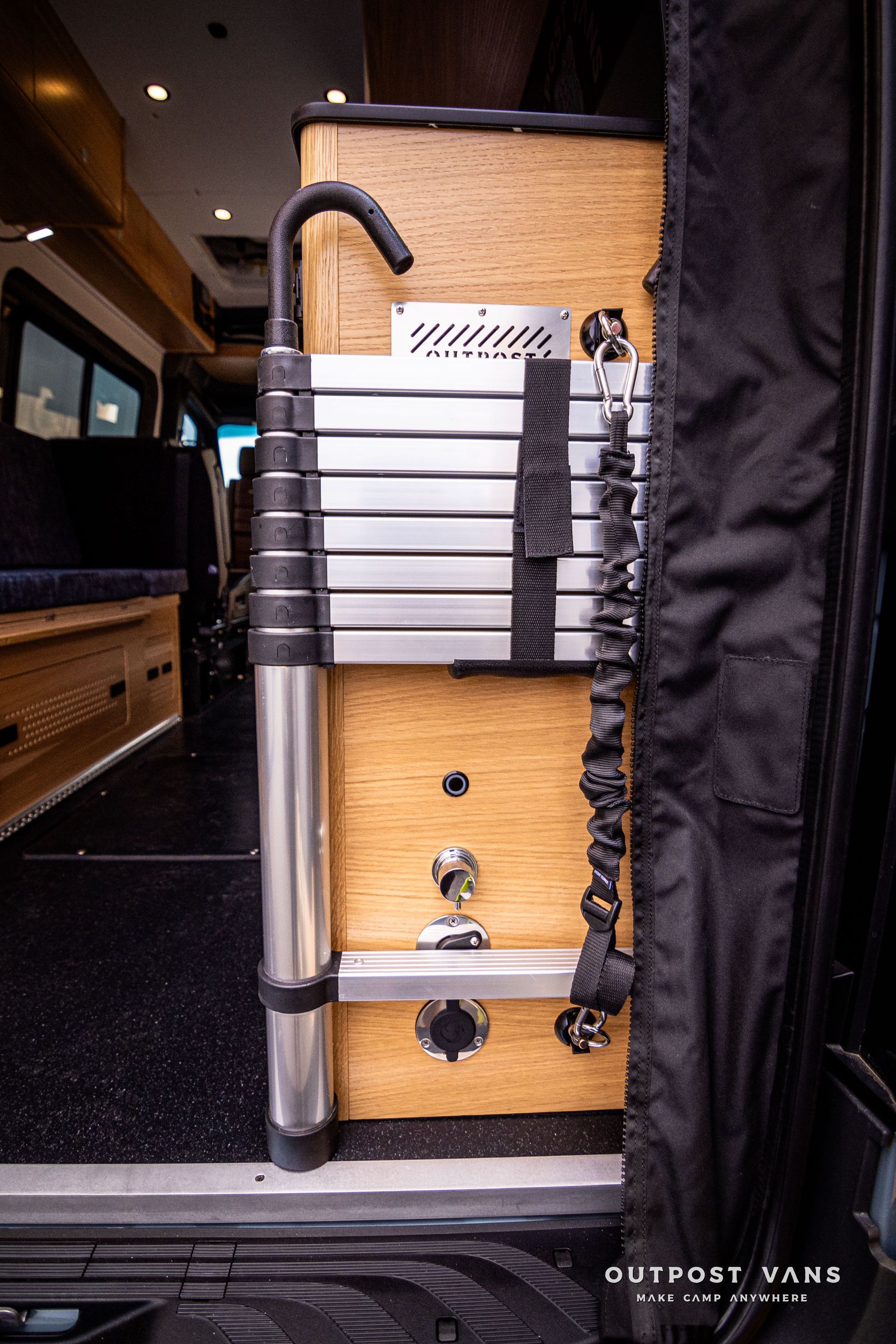 A ladder is attached to the side of a van.